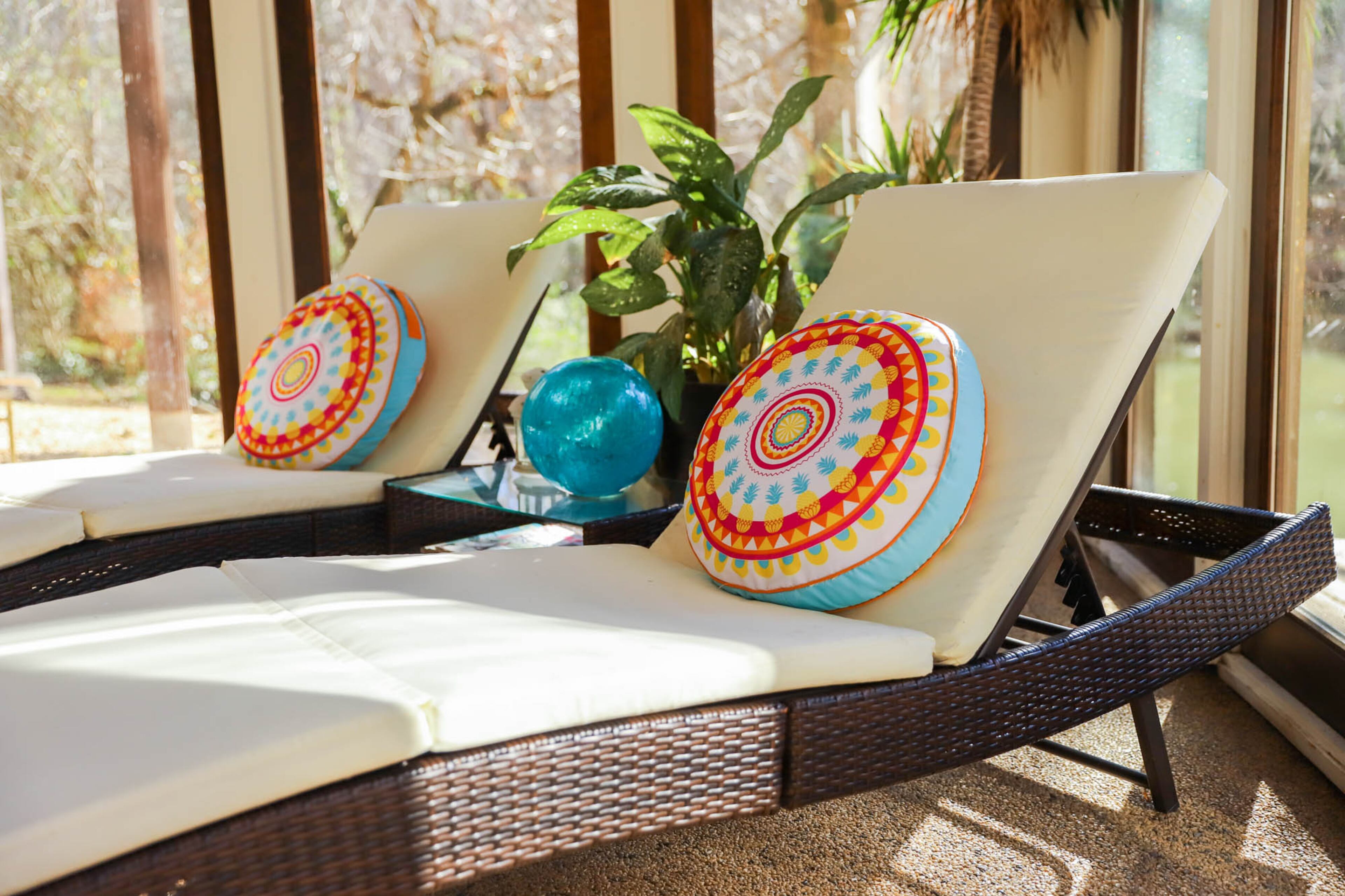 The light and airy indoor pool room has enough space for the family and their guests to relax in chaises decorated with colorful pillows.