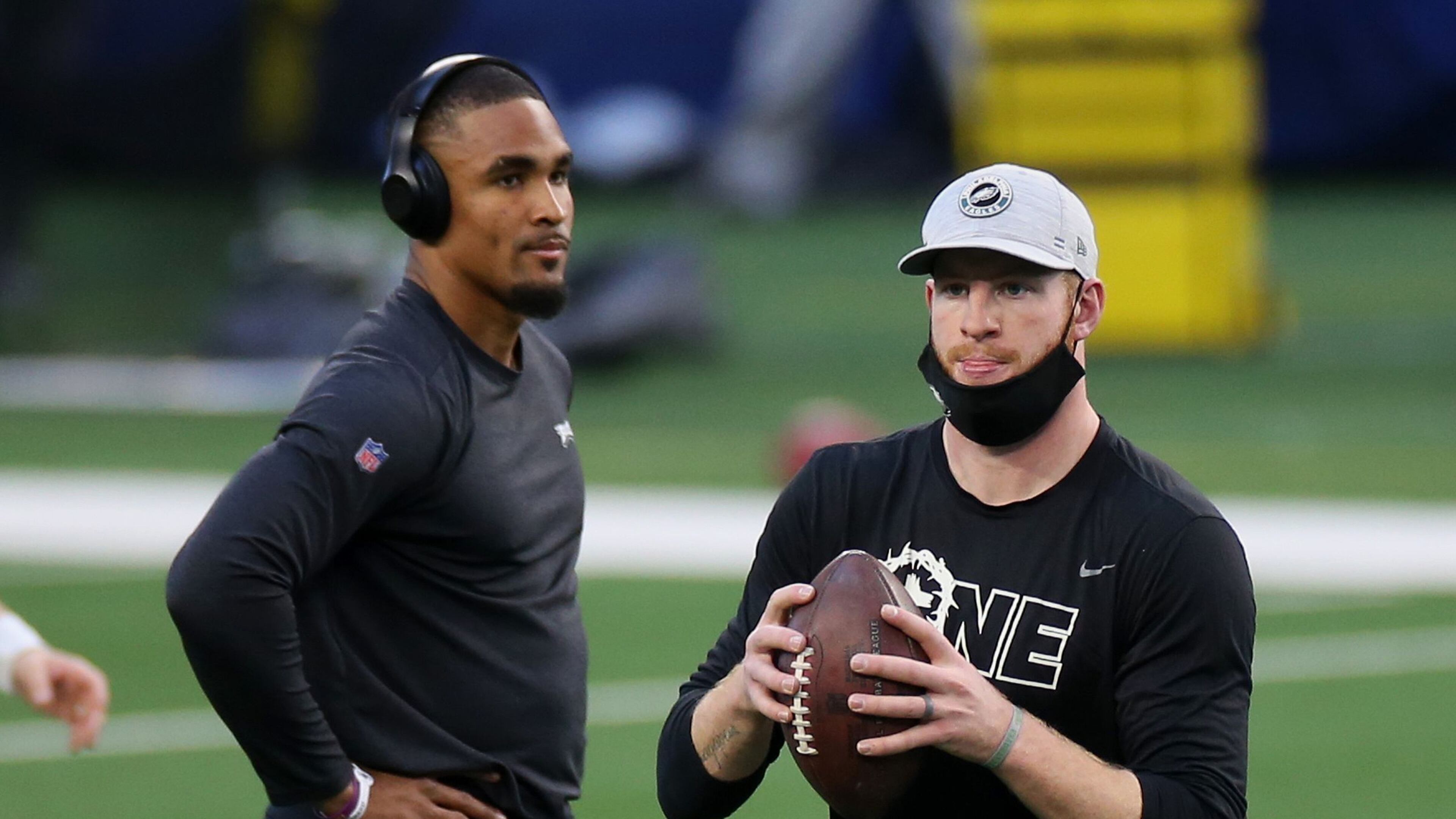 Eagles quarterbacks Jalen Hurts (left) and Carson Wentz warm up before a game against the Dallas Cowboys in December.