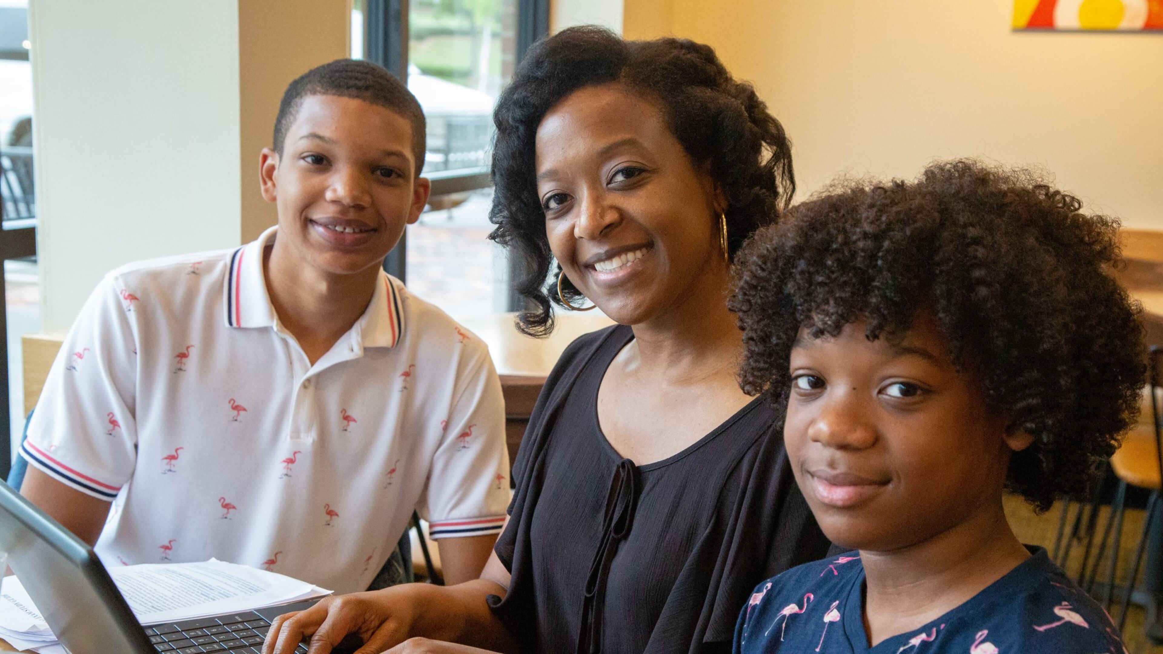 Athara Toussaint (center), searches for her grades online while having breakfast with her sons Dallas (left, age 17) and Julian (14).