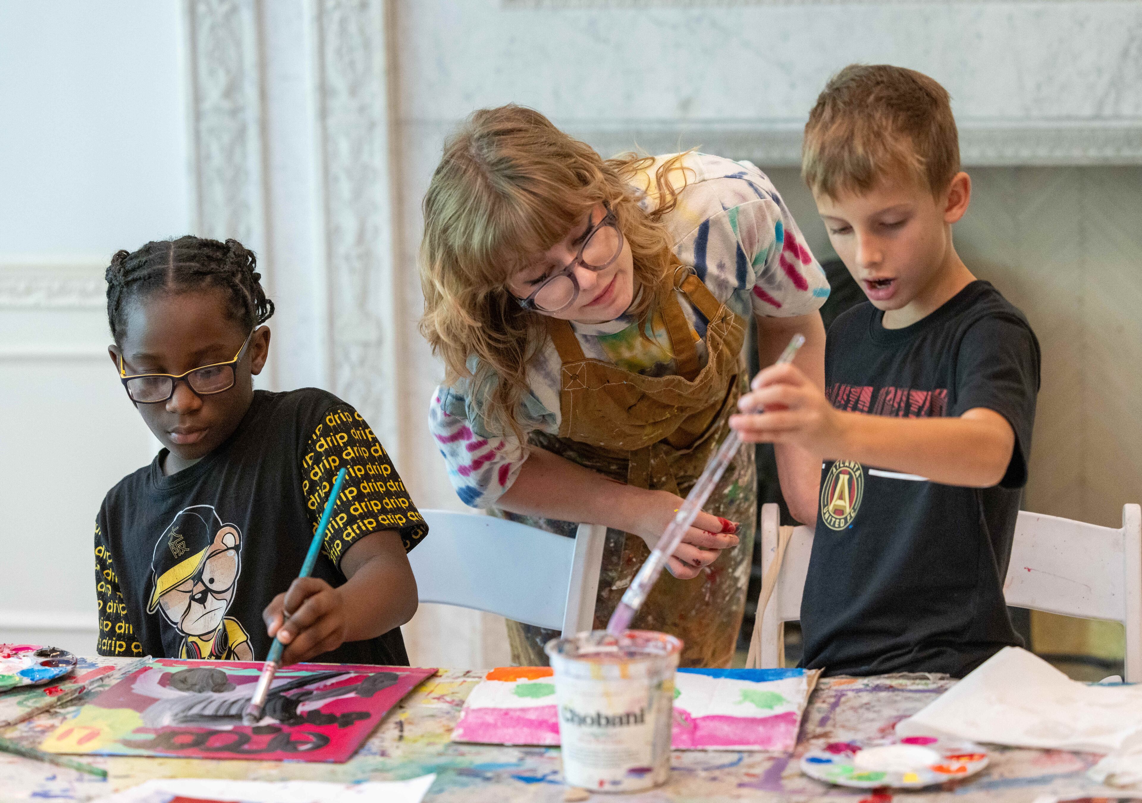 (l-r) Kevin Jones works on his painting as teacher Ella Kimberly helps William Moravian with his during a summer camp at Callanwolde Fine Arts Center. PHIL SKINNER FOR THE ATLANTA JOURNAL-CONSTITUTION