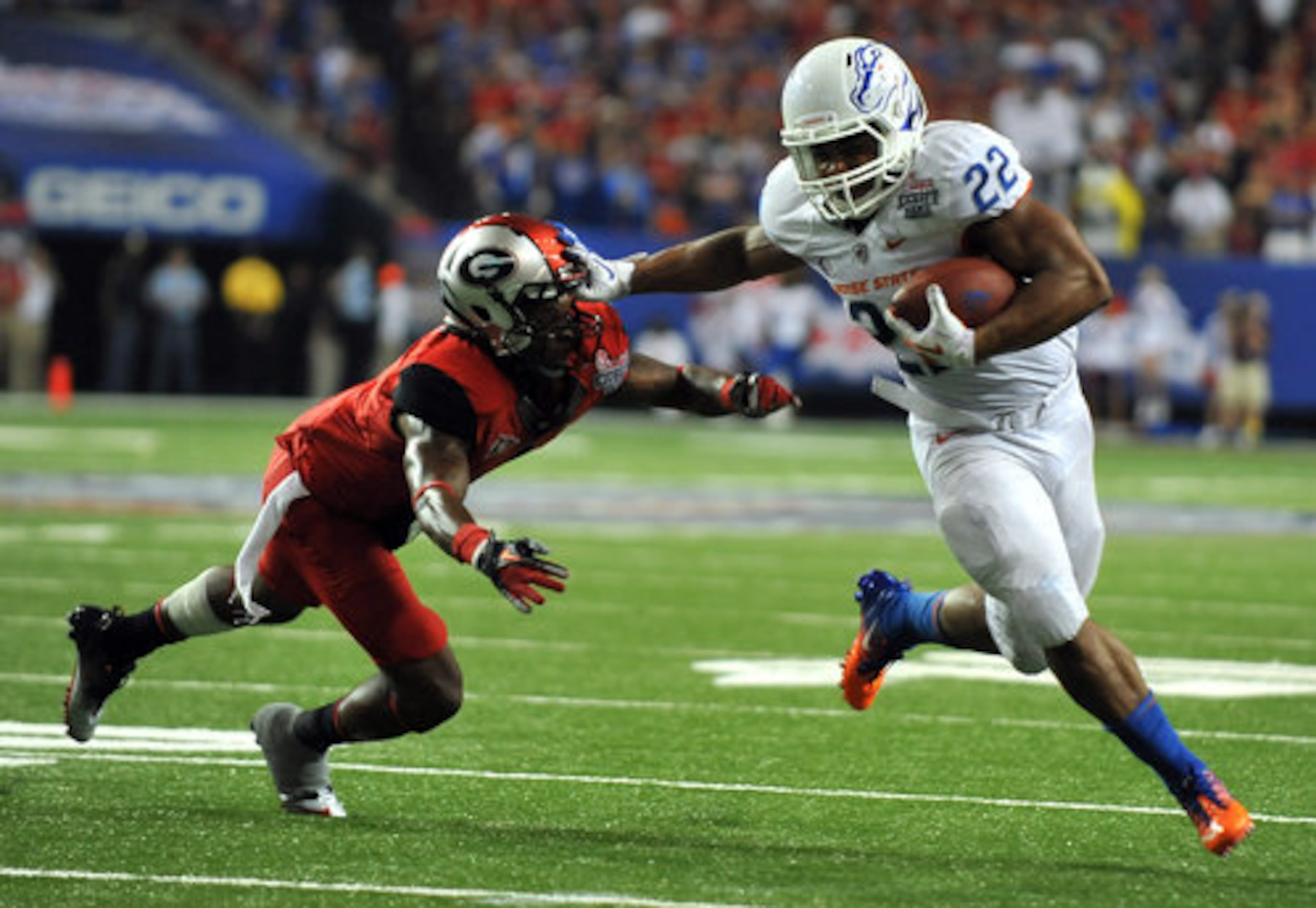 Boise State running back Doug Martin stiff arms Georgia defender Branden Smith in route to third quarter touchdown and a 21-7 lead.