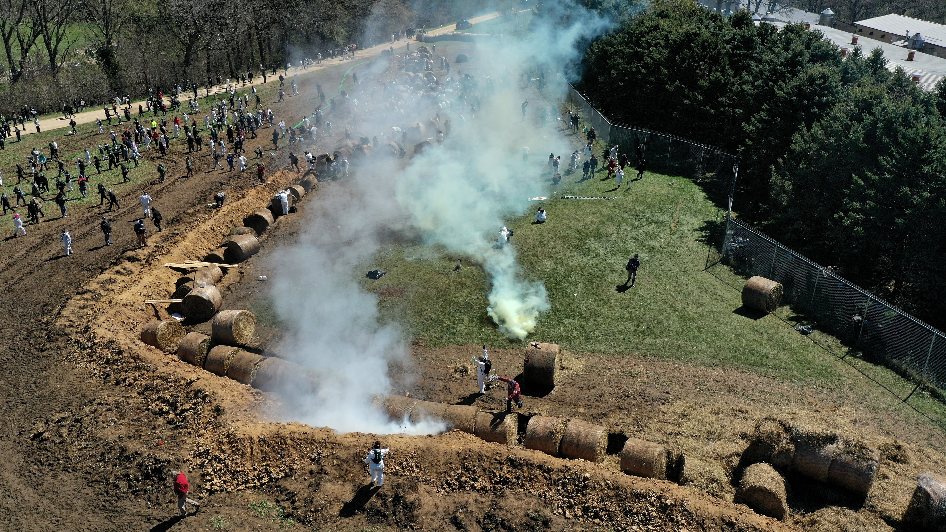 Animal rights activists react to tear gas while attempting to gain entry into Ridglan Farms beagle breeding and research facility in Blue Mounds, Wis., Saturday, April 18, 2026. (Amber Arnold/Wisconsin State Journal via AP)