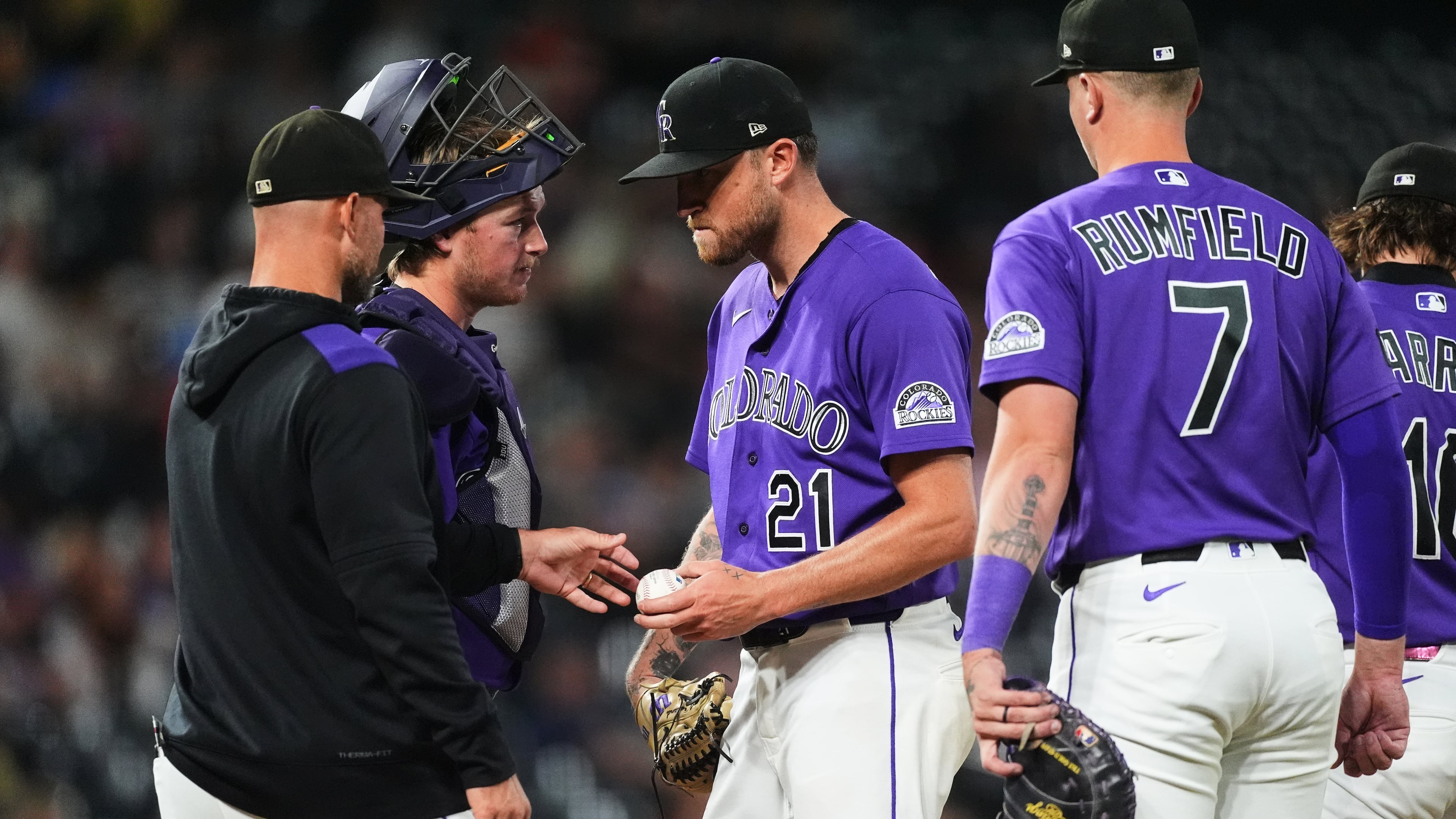 Colorado Rockies starting pitcher Kyle Freeland, center, hands the ball as he is pulled from the mound to manager Warren Schaeffer, front left, as catcher Hunter Goodman, back left, and first baseman TJ Rumfield look on in the fourth inning of a baseball game against the Arizona Diamondbacks Tuesday, Sept. 22, 2026, in Denver. (AP Photo/David Zalubowski)