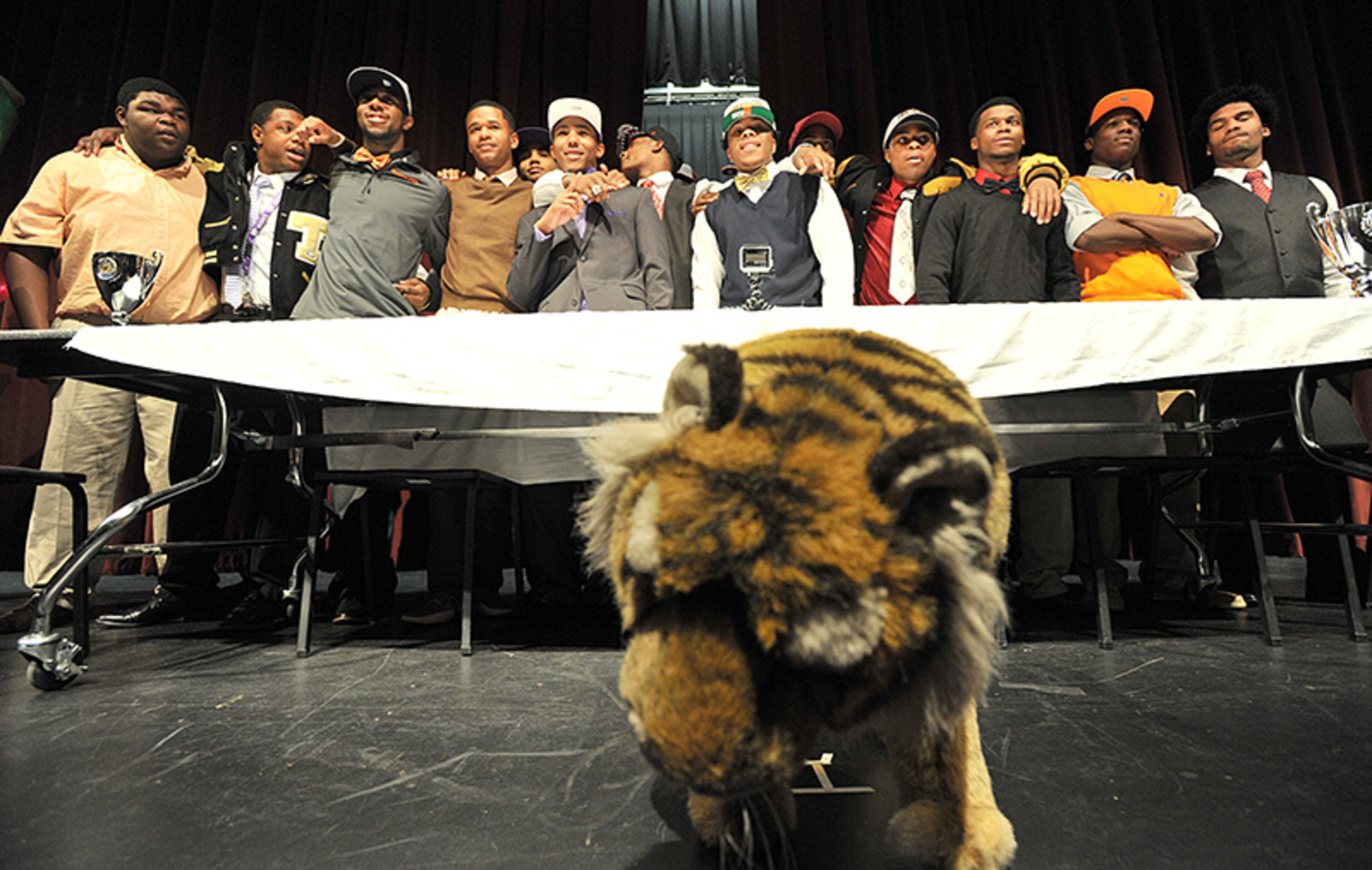 Sixteen Tucker High School football players pose for a group photo after they declared their college choices during signing day at Tucker High School.