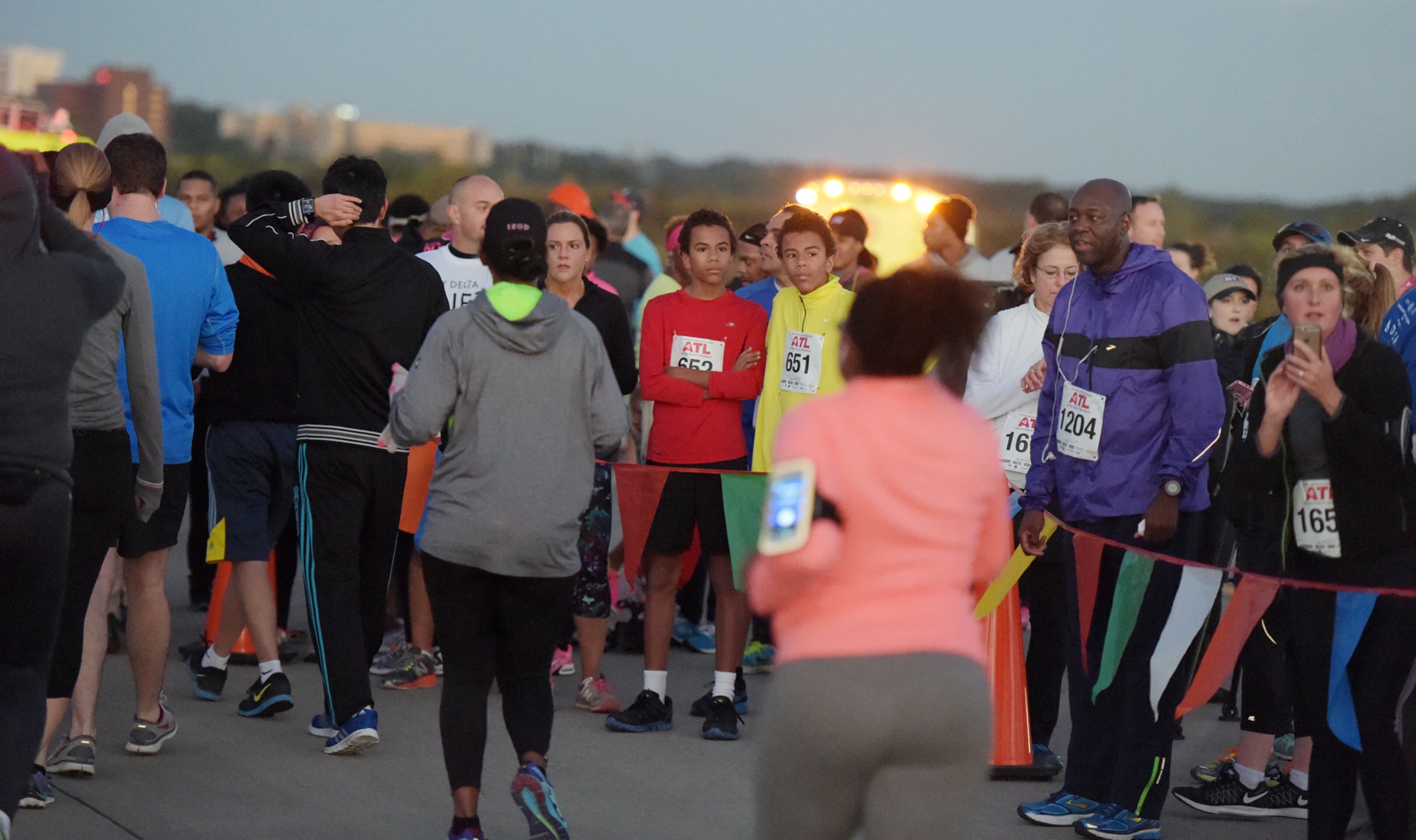 OCTOBER 17, 2015 ATLANTA Runners cross the finish line as the sun rises. Mayor Kasim Reed and United Way President Milton Little joined more than 2,000 runners at the Mayor’s Inaugural 5K on the 5th Runway at the world’s busiest airport Saturday, October 17, 2015. Airport officials shut down the 5th runway (Runway 10/28) until 8:15 am so runners and walkers could exit the course. All proceeds from the event will benefit United Way of Greater Atlanta. Major sponsors of The Mayor’s Inaugural 5K on the 5th Runway include Delta Air Lines, The Coca-Cola Company, Enterprise Rental Car, Georgia International Convention Center, MARTA, and Publix. Over $123,000 was raised, said airport spokesman Reese McCranie. The race's overall winner was Andrew Murfee, 15, a Woodward Academy student. KENT D. JOHNSON/KDJOHNSON@AJC.COM