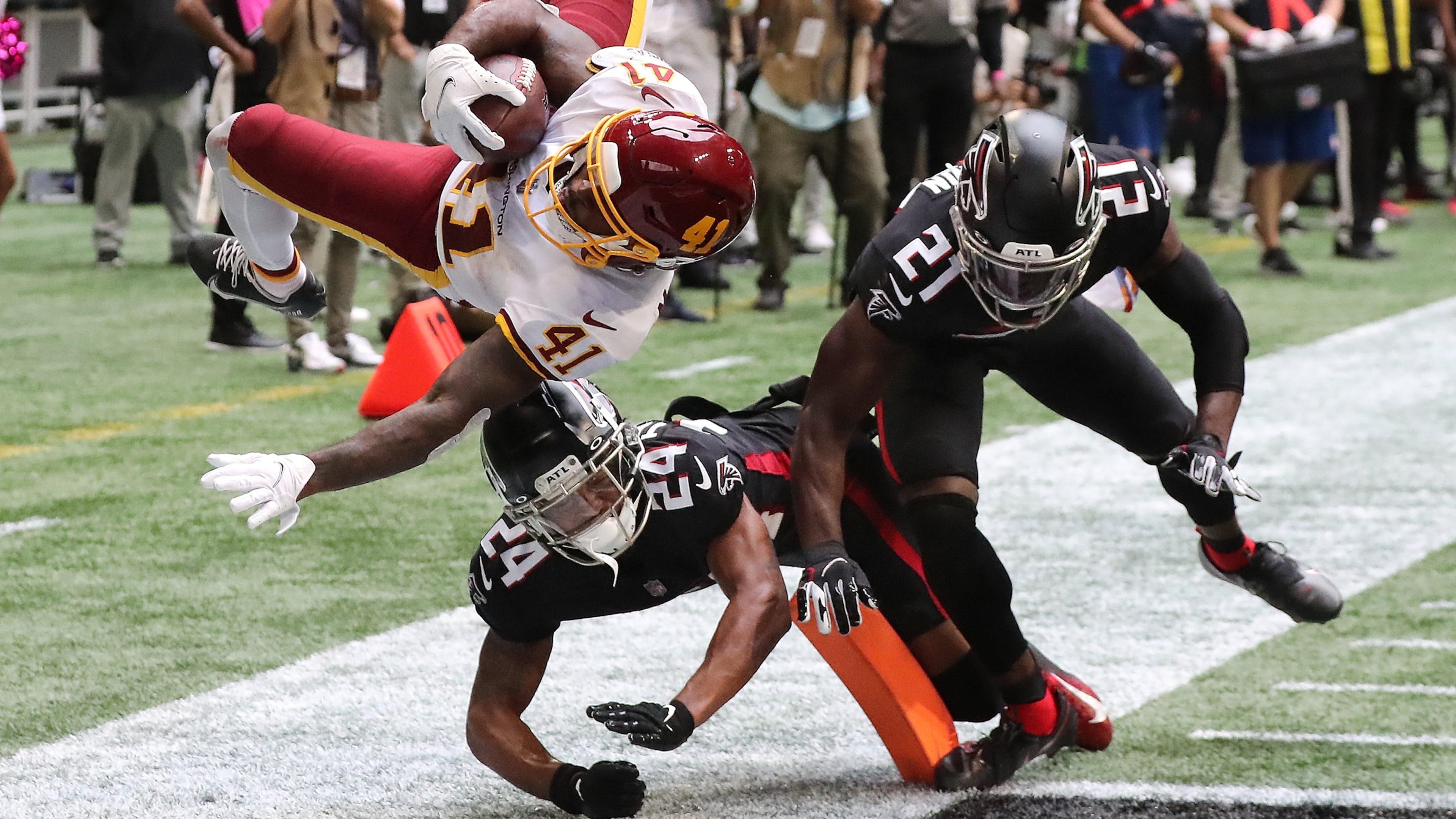 Washington Football Team running back J.D. McKissic gets into the end zone for the game-winning touchdown with Falcons cornerback A.J. Terrell (left) and safety Duron Harmon arriving late with the hit during the final minute Sunday, Oct. 3, 2021, at Mercedes-Benz Stadium in Atlanta. The Falcons lost 34-30. (Curtis Compton / Curtis.Compton@ajc.com)