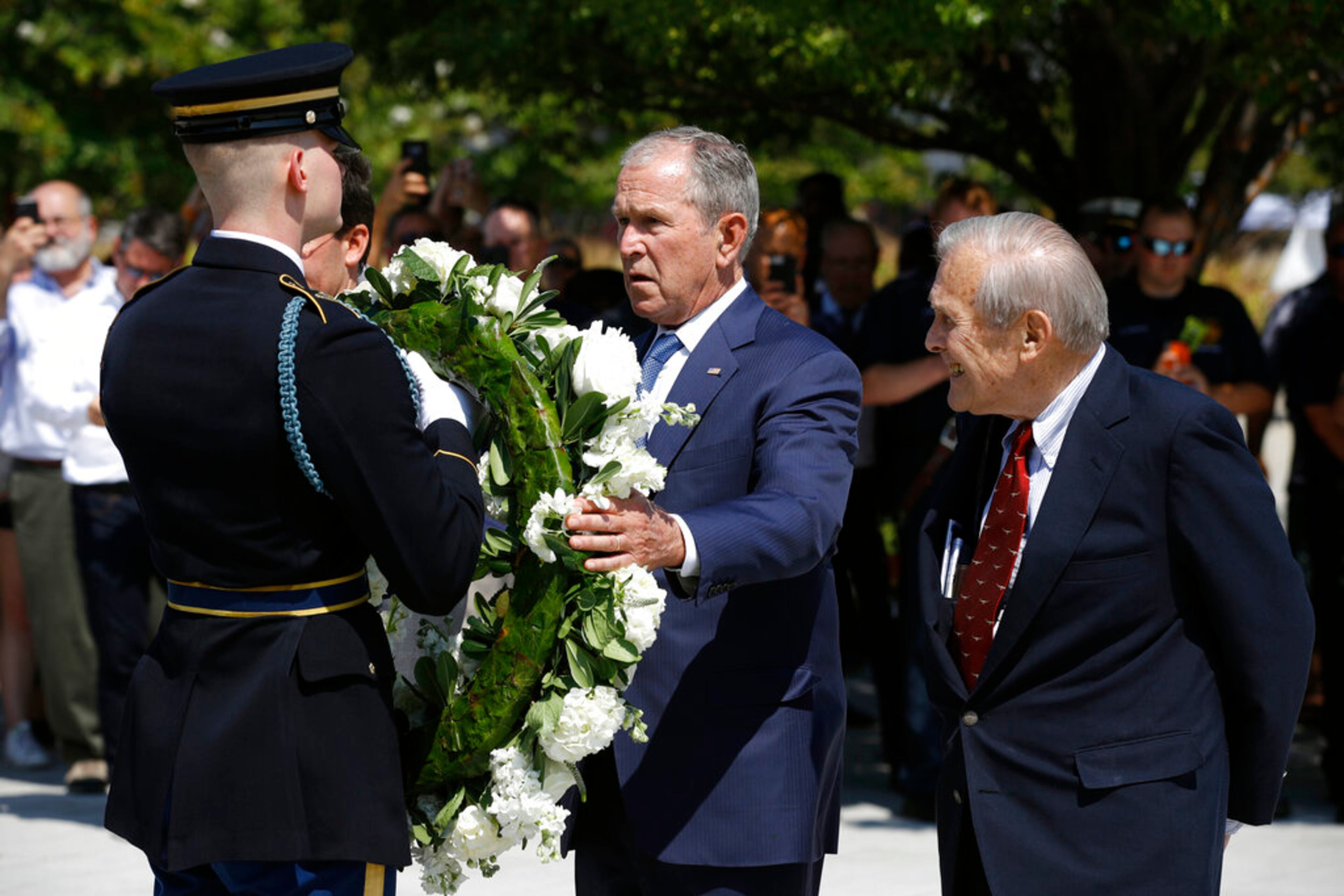 Former President George W. Bush places a wreath as former Defense Secretary Donald Rumsfeld, right, watches, on the grounds of the National 9/11 Pentagon Memorial at the Pentagon in Washington, Wednesday, Sept. 11, 2019, in observance of the 18th anniversary of the September 11th attacks. (AP Photo/Patrick Semansky)
