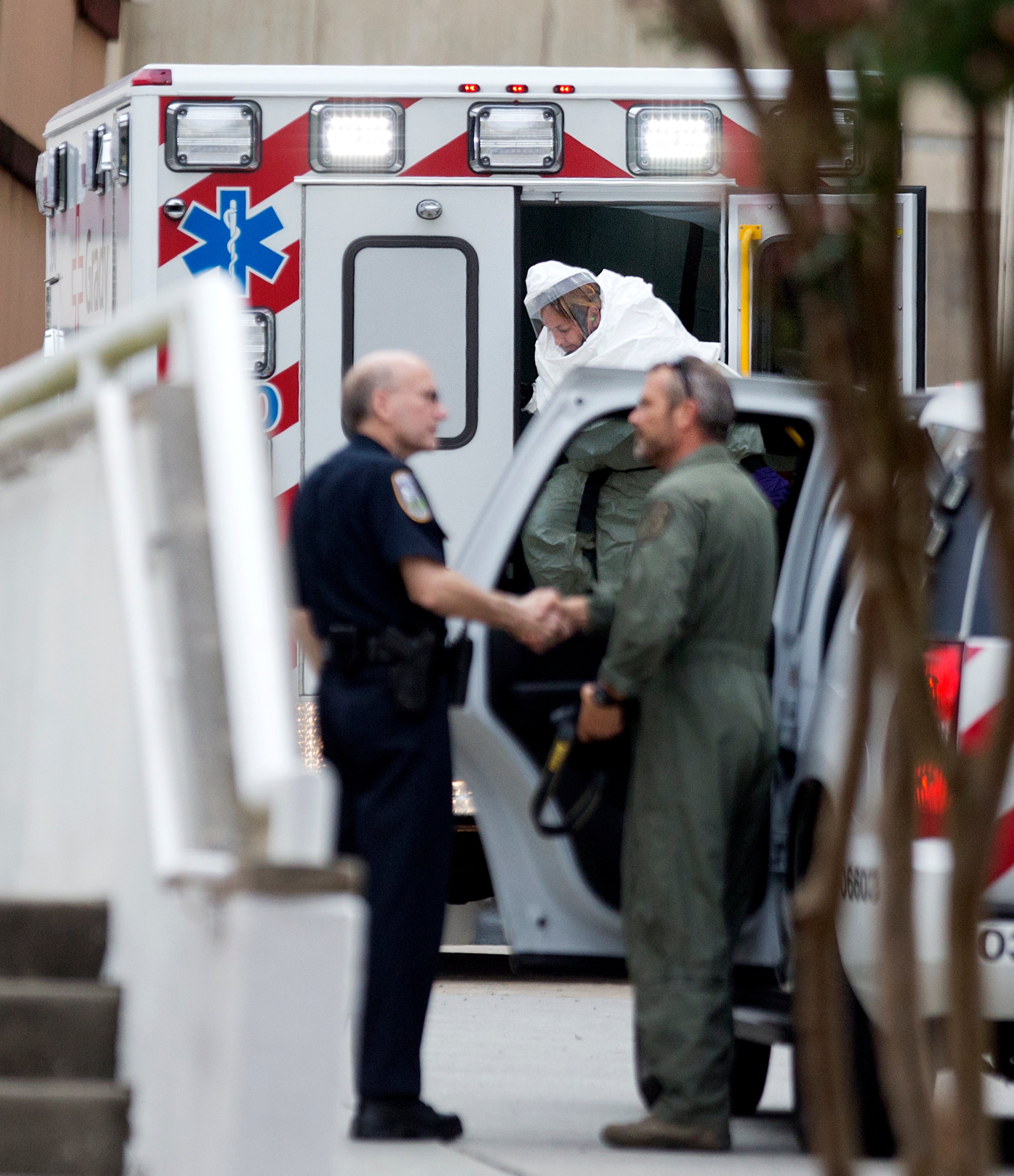 A person wearing a haz-mat suit steps out of an ambulance as an ebola patient arrives for treatment, Tuesday, Sept. 9, 2014, in Atlanta. The fourth American aid worker sickened with the Ebola virus arrived Tuesday morning for treatment at Emory University Hospital, where two others have been successfully treated. (AP Photo/David Goldman)