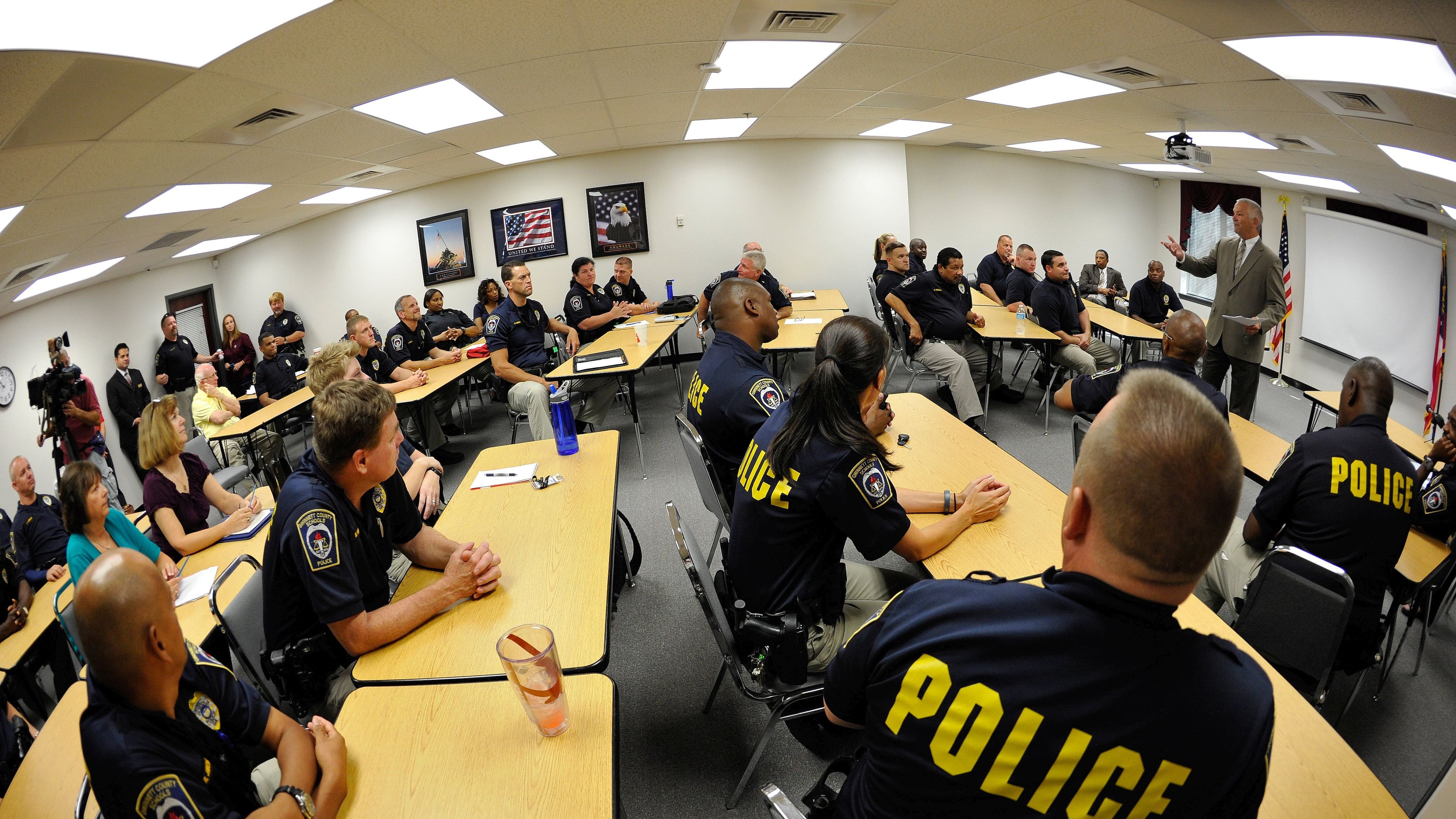 Wayne Rikard, Gwinnett County Schools chief of police safety and security, right, recognizes veteran school resource officers as they train for the 2014-15 school year on Wednesday, July 23, 2014, in Lawrenceville, Ga., marking the first time Gwinnett schools will have armed officers in all of its middle schools. Gwinnett officials say the need for more officers has been driven by school shootings in places like Columbine and Sandy Hook. David Tulis / AJC Special