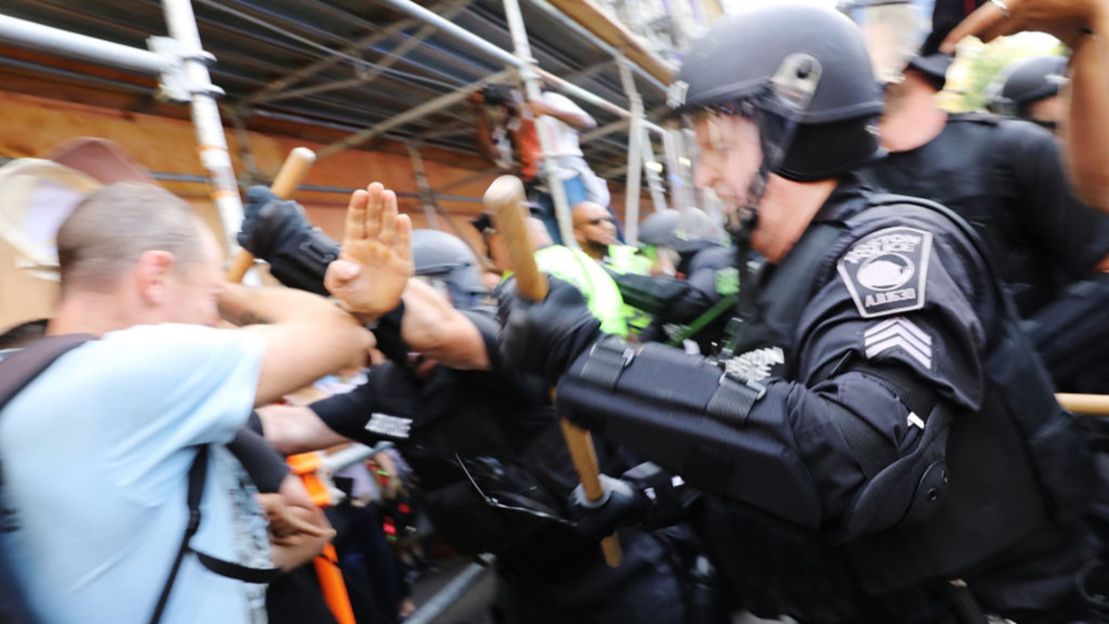 BOSTON, MA - AUGUST 19: Protesters face off with riot police escorting conservative activists following a march in Boston against a planned 'Free Speech Rally' just one week after the violent 'Unite the Right' rally in Virginia left one woman dead and dozens more injured on August 19, 2017 in Boston, United States. Although the rally organizers stress that they are not associated with any alt-right or white supremacist groups, the city of Boston and Police Commissioner William Evans are preparing for possible confrontations at the afternoon rally. (Photo by Spencer Platt/Getty Images)