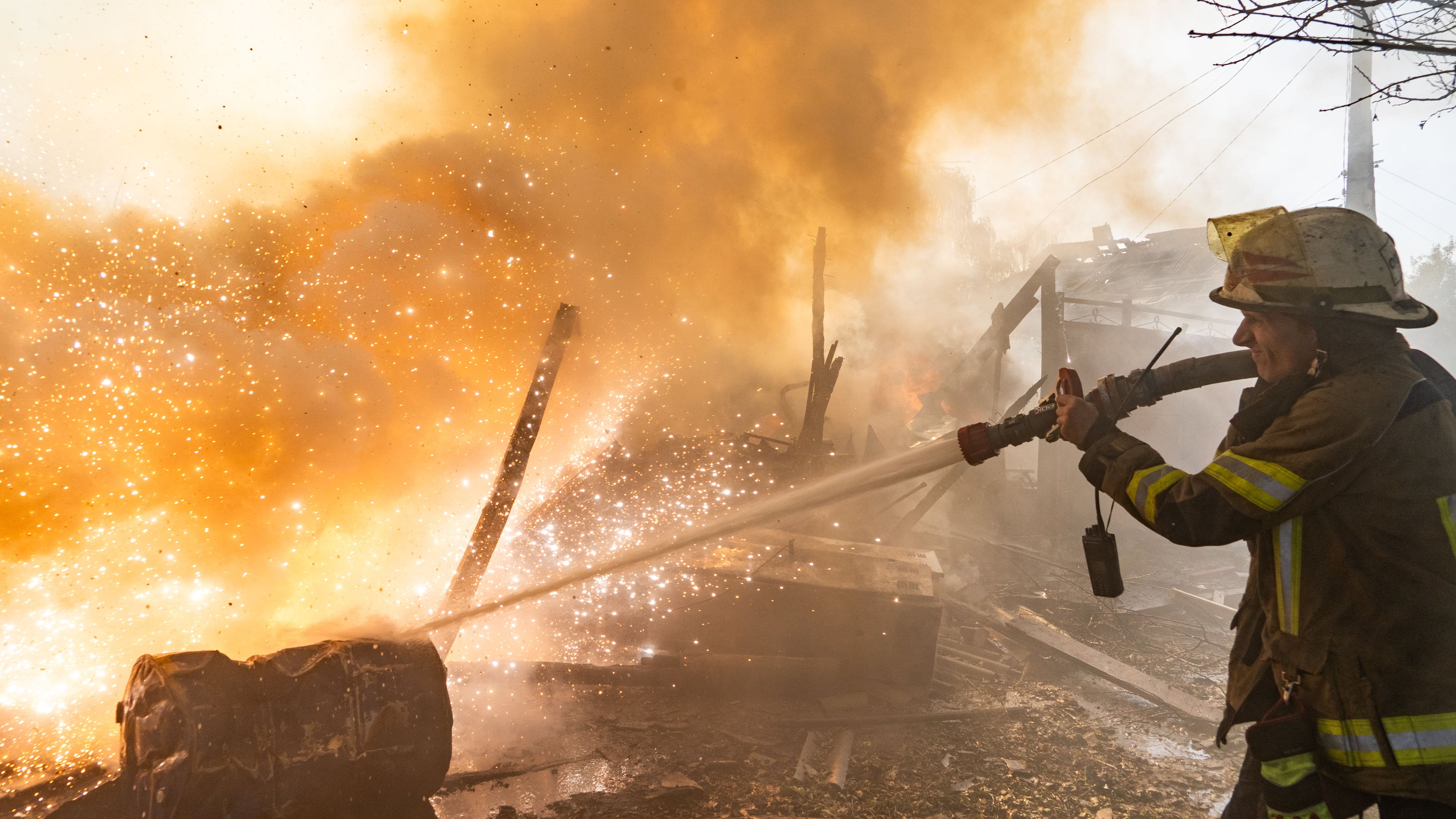 A rescue worker puts out a fire at residential houses destroyed in a Russian strike on Kharkiv, Ukraine, Sunday, Oct. 11, 2026. (AP Photo/Andrii Marienko)