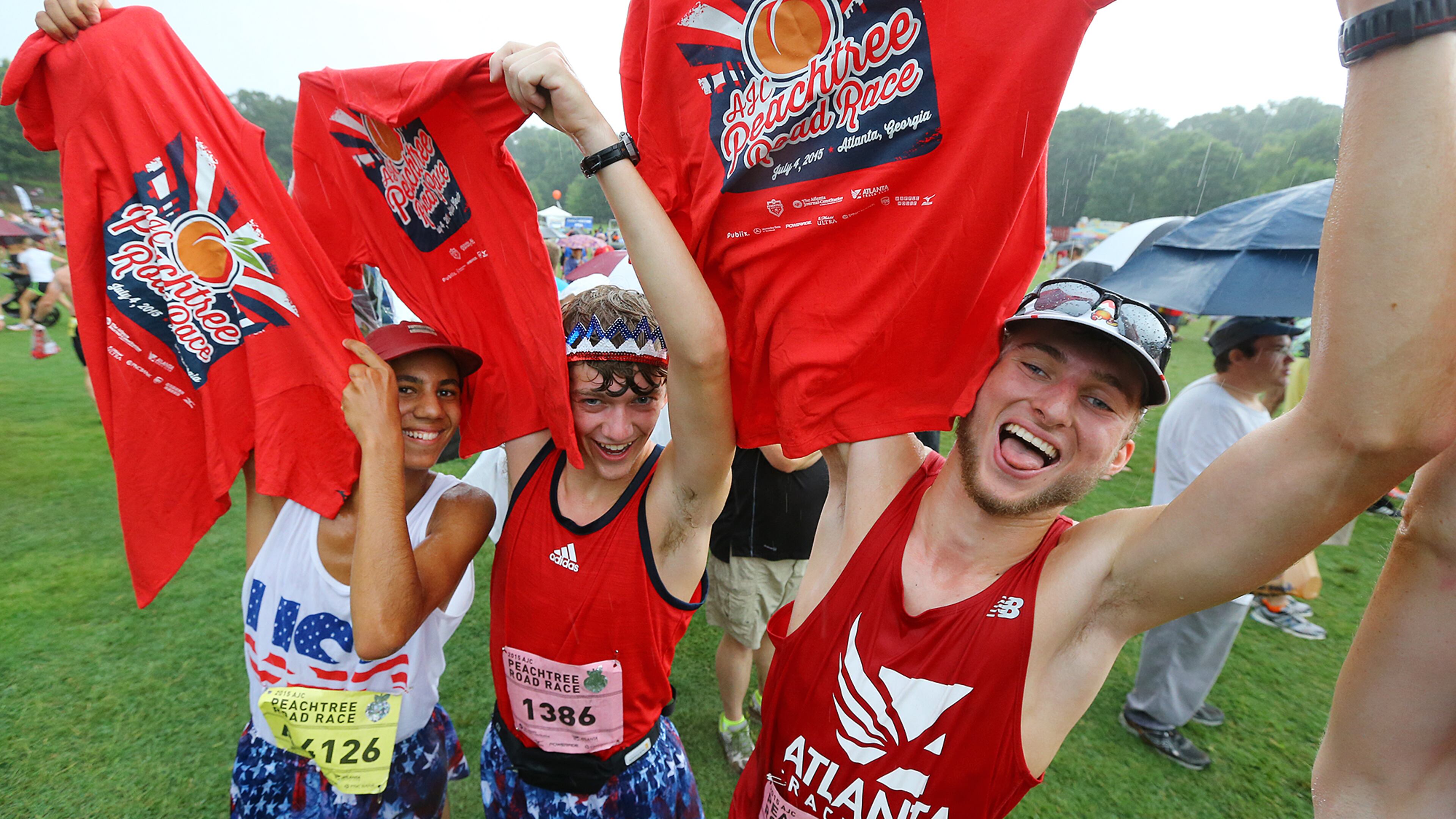 070415 ATLANTA: Max Rabin (from left), Adam Burkley and Hayden Cox, from Johns Creek, celebrate with their t-shirts in Piedmont Park after finishing the AJC Peachtree Road Race on Saturday, July 4, 2015, in Atlanta. Curtis Compton / ccompton@ajc.com