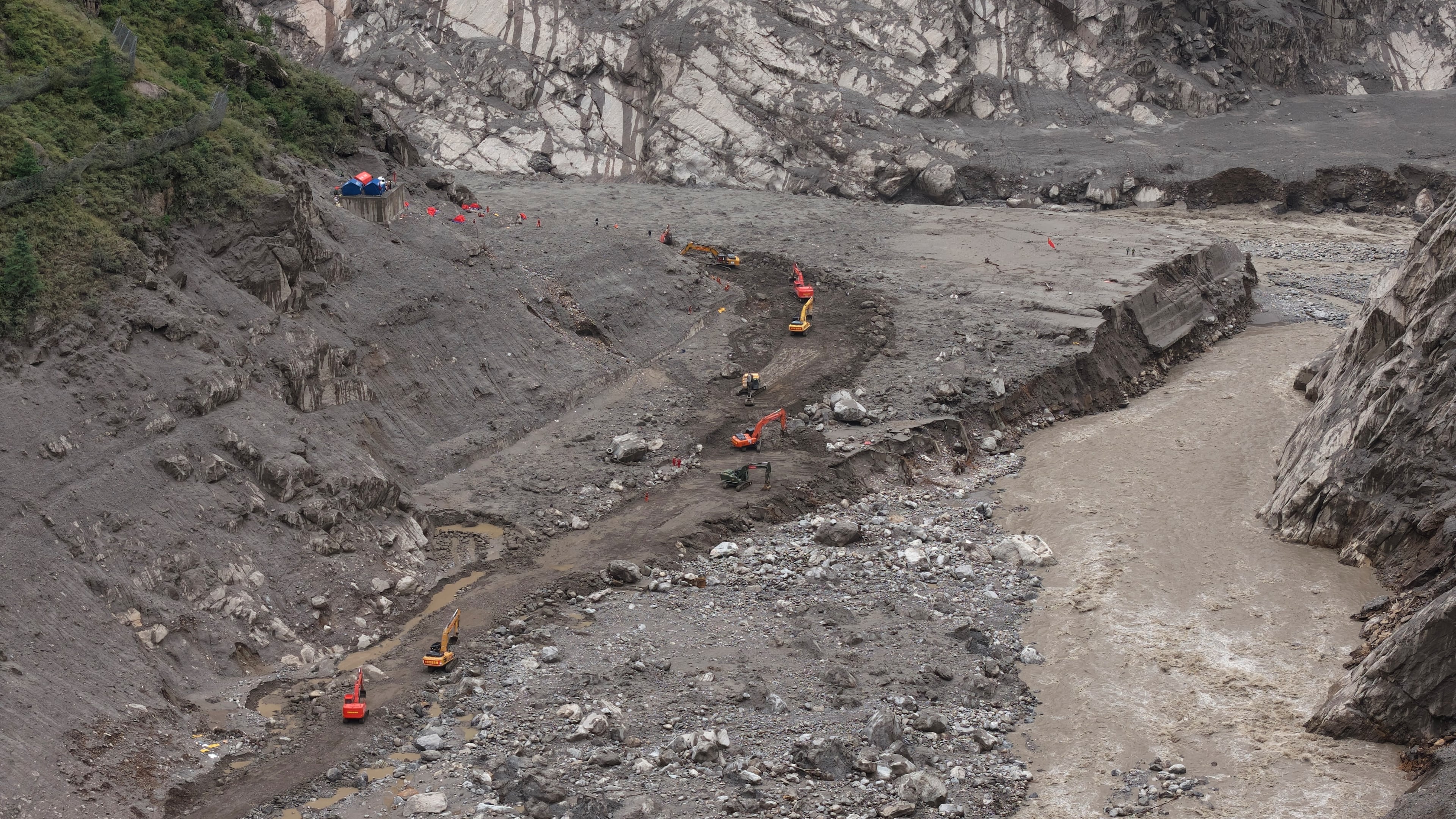 In this photo released by Xinhua News Agency, rescuers use excavators to clear a road at the core area of the mudslide-hit Gyirong Port in Gyirong County, southwestern China's Tibet Autonomous Region, Wednesday, Sept. 2, 2026. (Tenzing Nima Qadhup/Xinhua via AP)