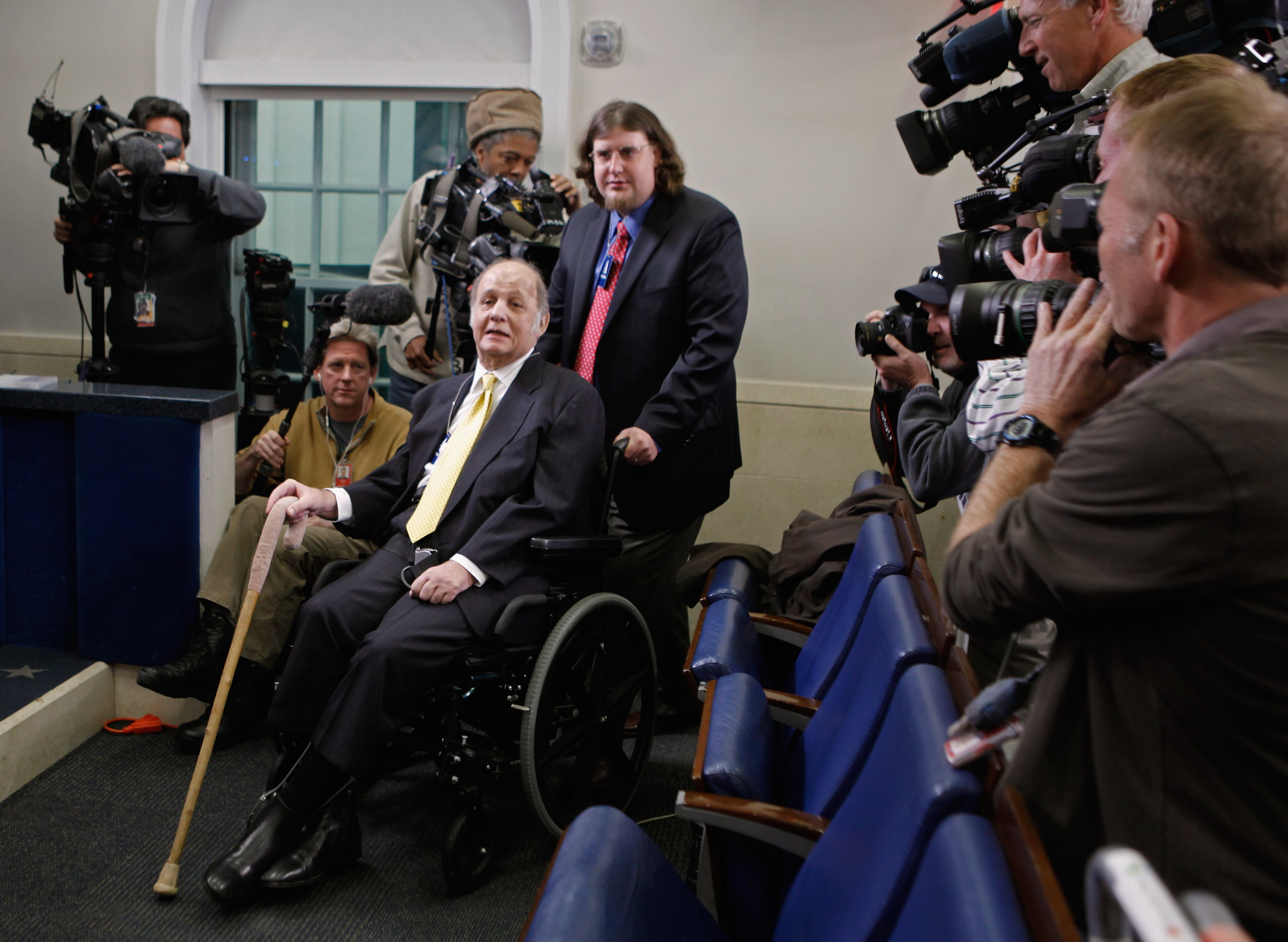 WASHINGTON, DC - MARCH 30: Television cameras record the arrival of former White House Press Secretary James Brady (2nd R) as he and his son, Scott Brady (R), visit the press briefing room that bears his name in the West Wing of the White House March 30, 2011 in Washington, DC. Brady was visiting the White House on the 30th anniversary of the day he was shot in the head by John Hinckley, Jr., during his attempted assassination former President Ronald Reagan March 30, 1981. (Photo by Chip Somodevilla/Getty Images)