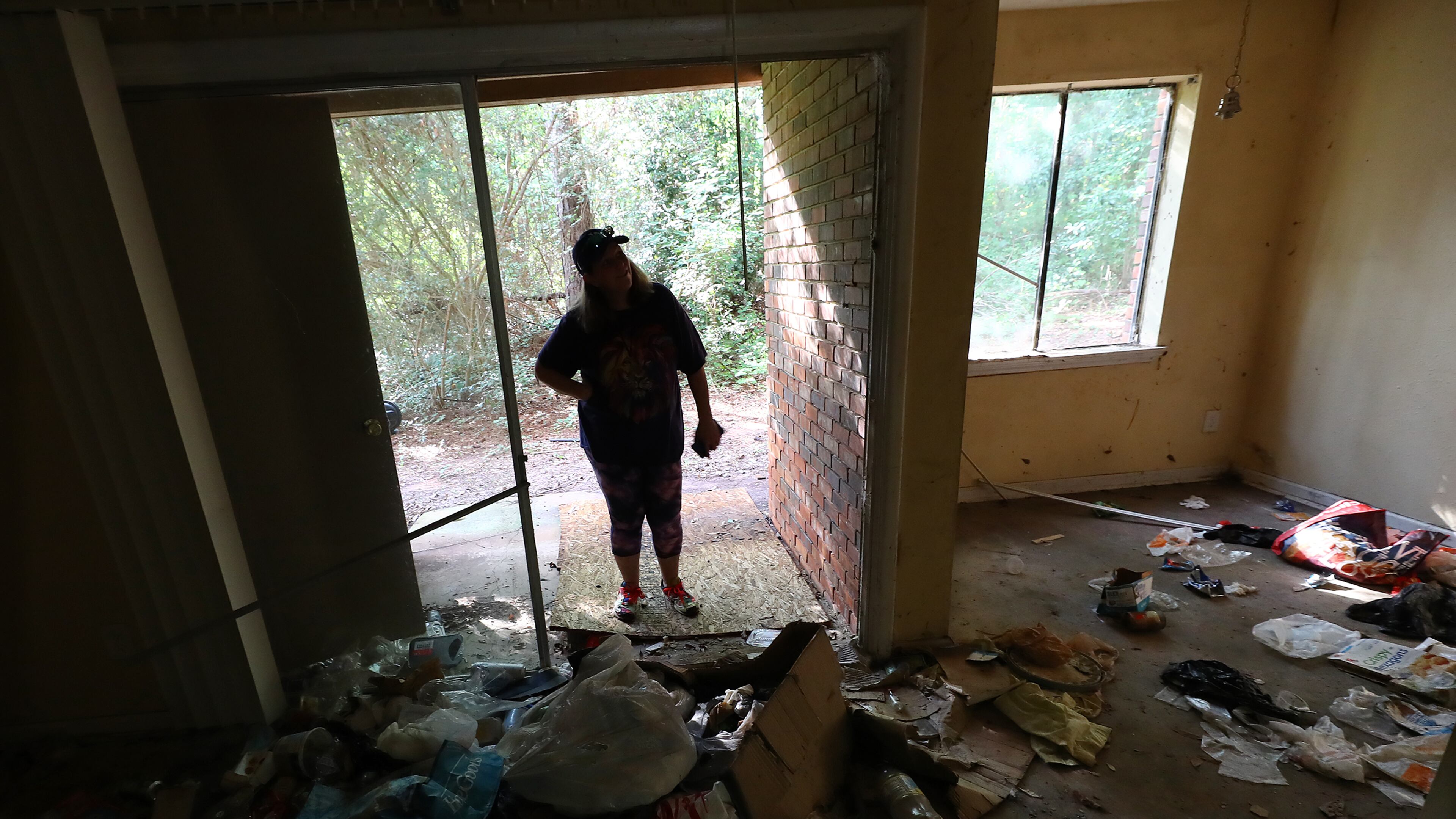 Decatur: Kristy Neff looks into an apartment in her unit where the windows are all broken out and trash litters the floor in The Village at Kensington on Sept. 6, 2022, in Decatur. “Curtis Compton / Curtis Compton@ajc.com