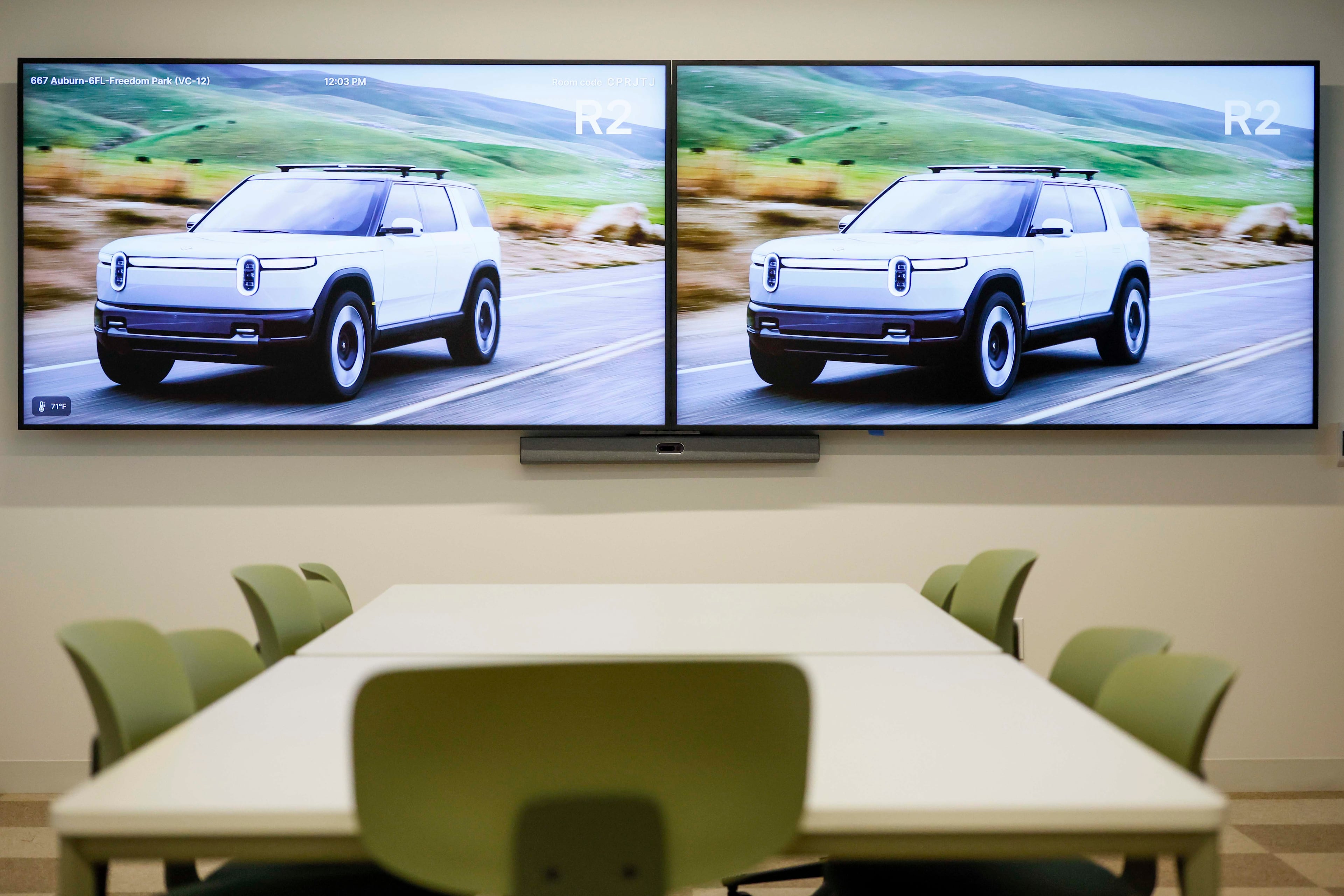 Monitors in a meeting room display Rivian R2 models at Rivian’s East Coast headquarters in Atlanta. (Miguel Martinez/AJC)
