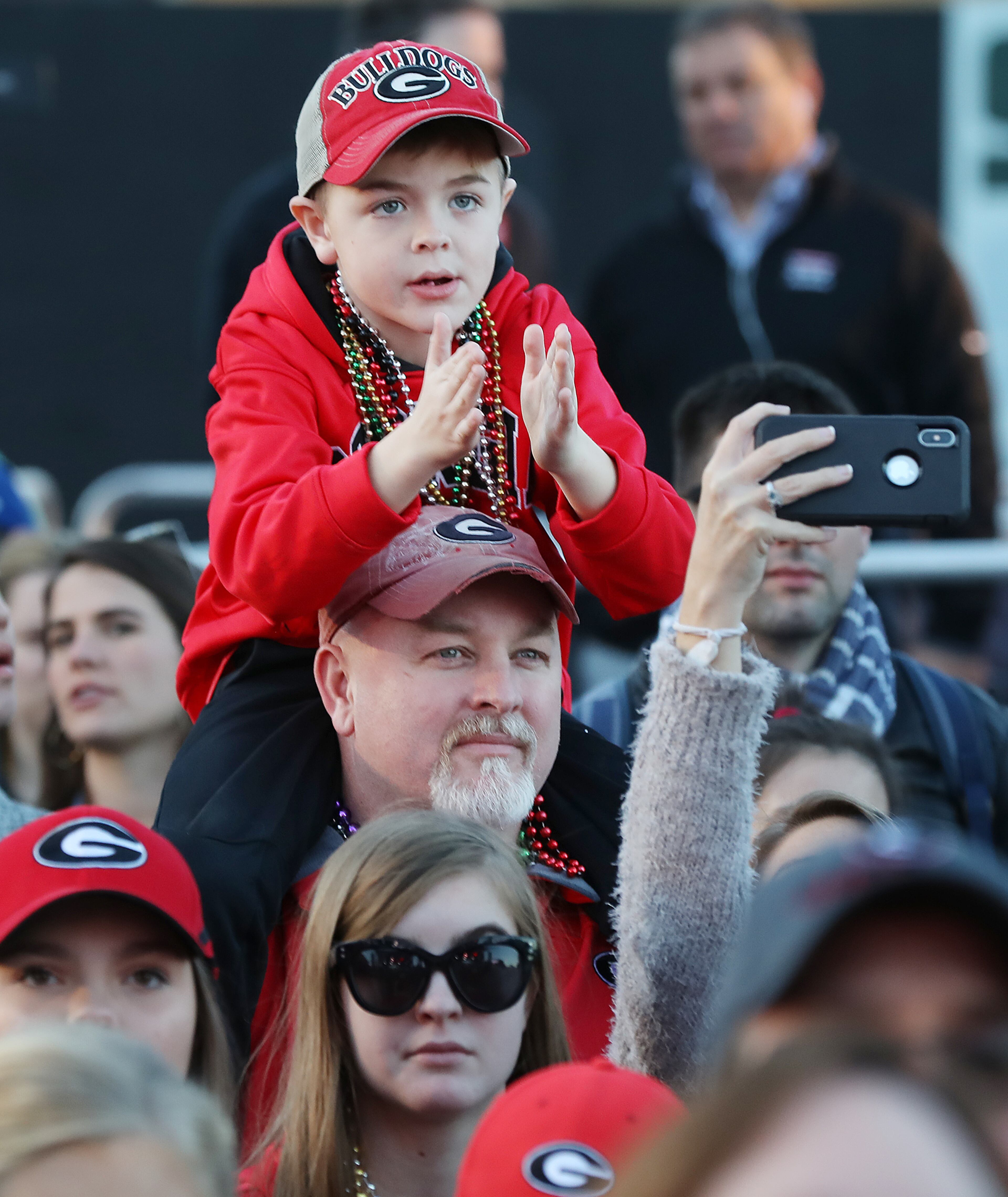 Ethan Denham, 7, has a view from the shoulders of his father Emmett Denham. Curtis Compton ccompton@ajc.com