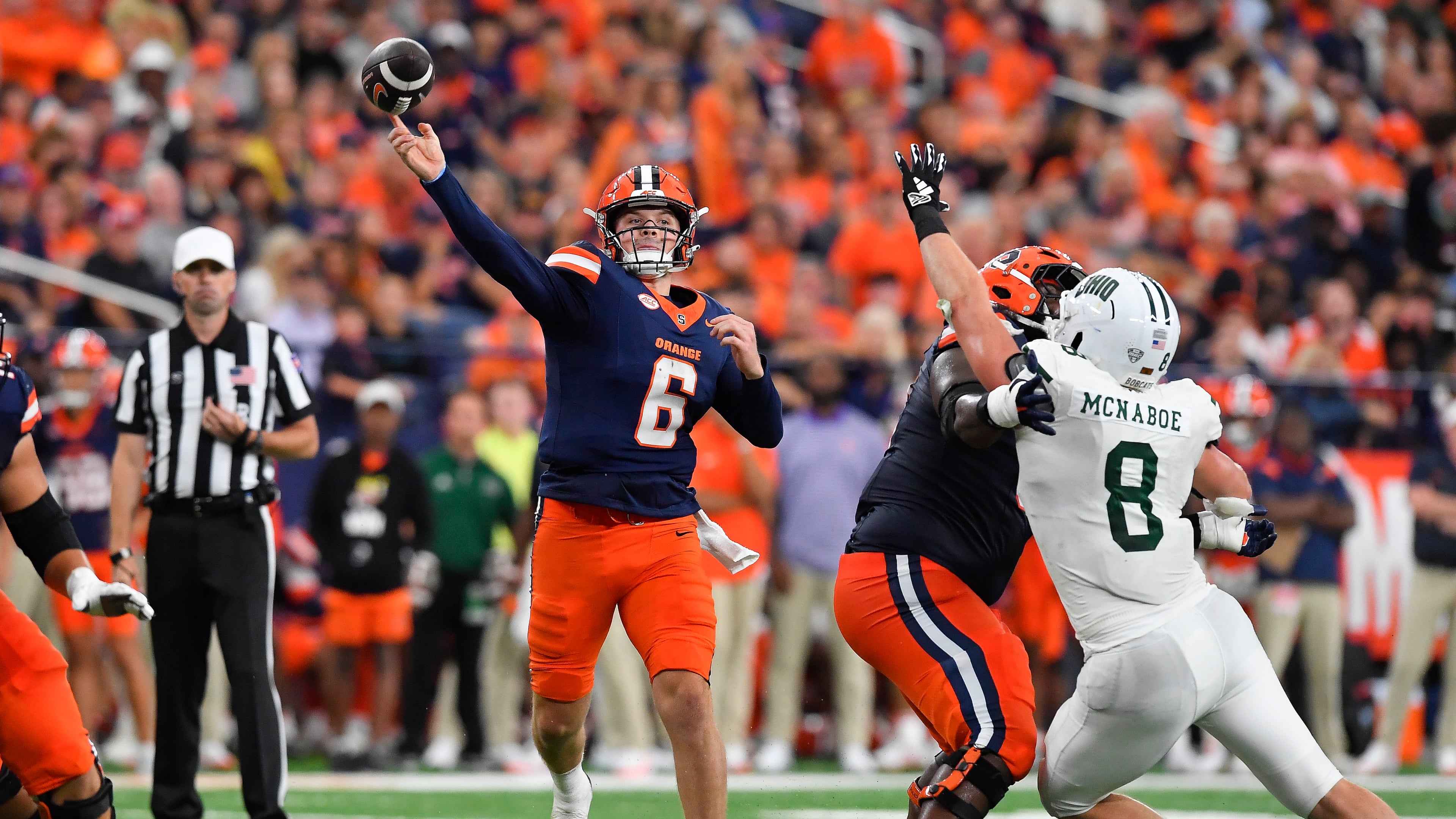 Syracuse quarterback Kyle McCord (6) throws a touchdown pass as offensive lineman Da'Metrius Weatherspoon blocks against Ohio defensive end Ben McNaboe (8) during the first half of an NCAA football game on Saturday, Aug. 31, 2024 in Syracuse, N.Y. (AP Photo/Adrian Kraus)