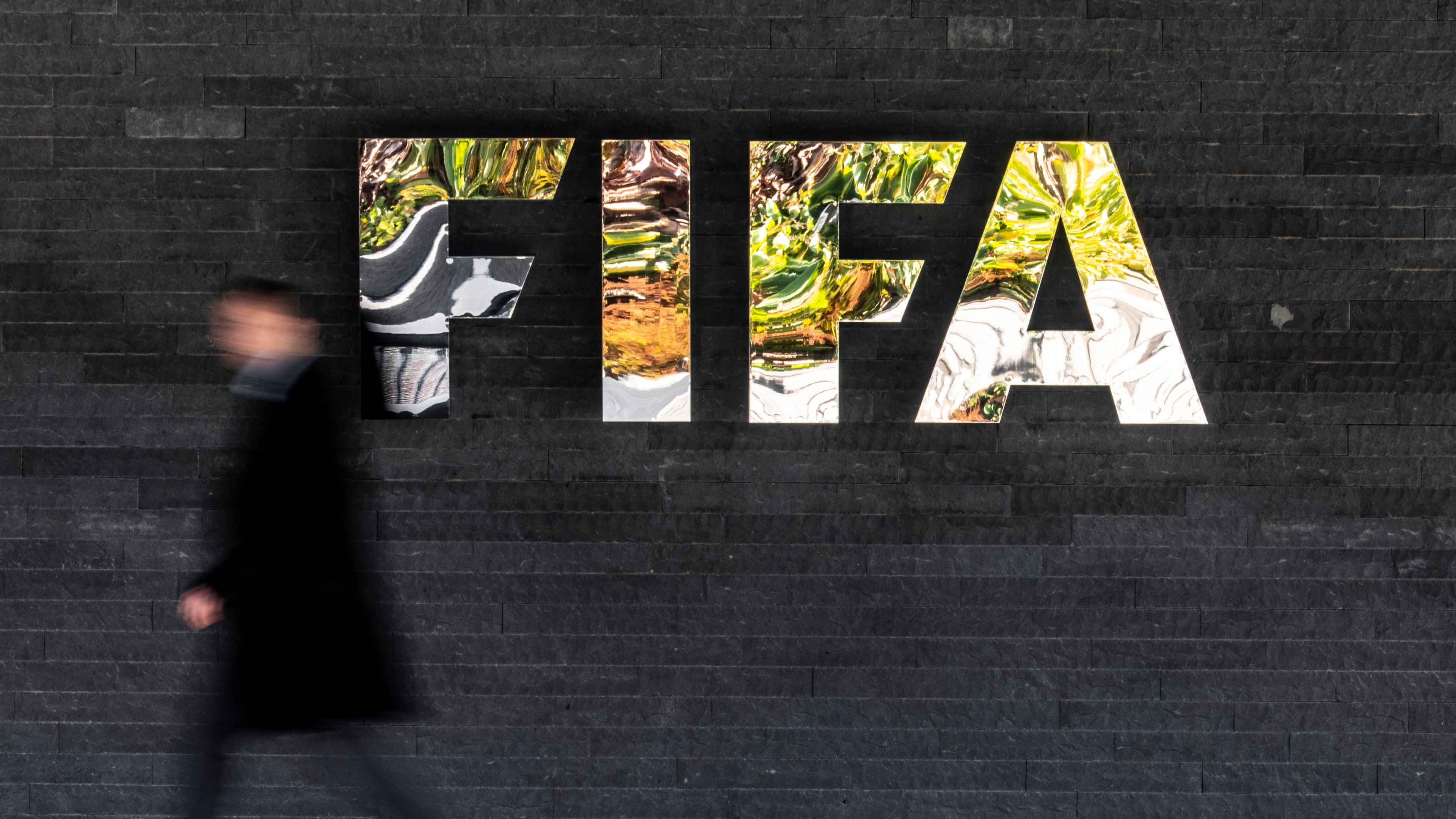 A man walks past a FIFA sign at the headquarters during the FIFA council meeting, in Zurich, Switzerland, Thursday, Oct. 15, 2026. (Claudio Thoma/Keystone via AP)