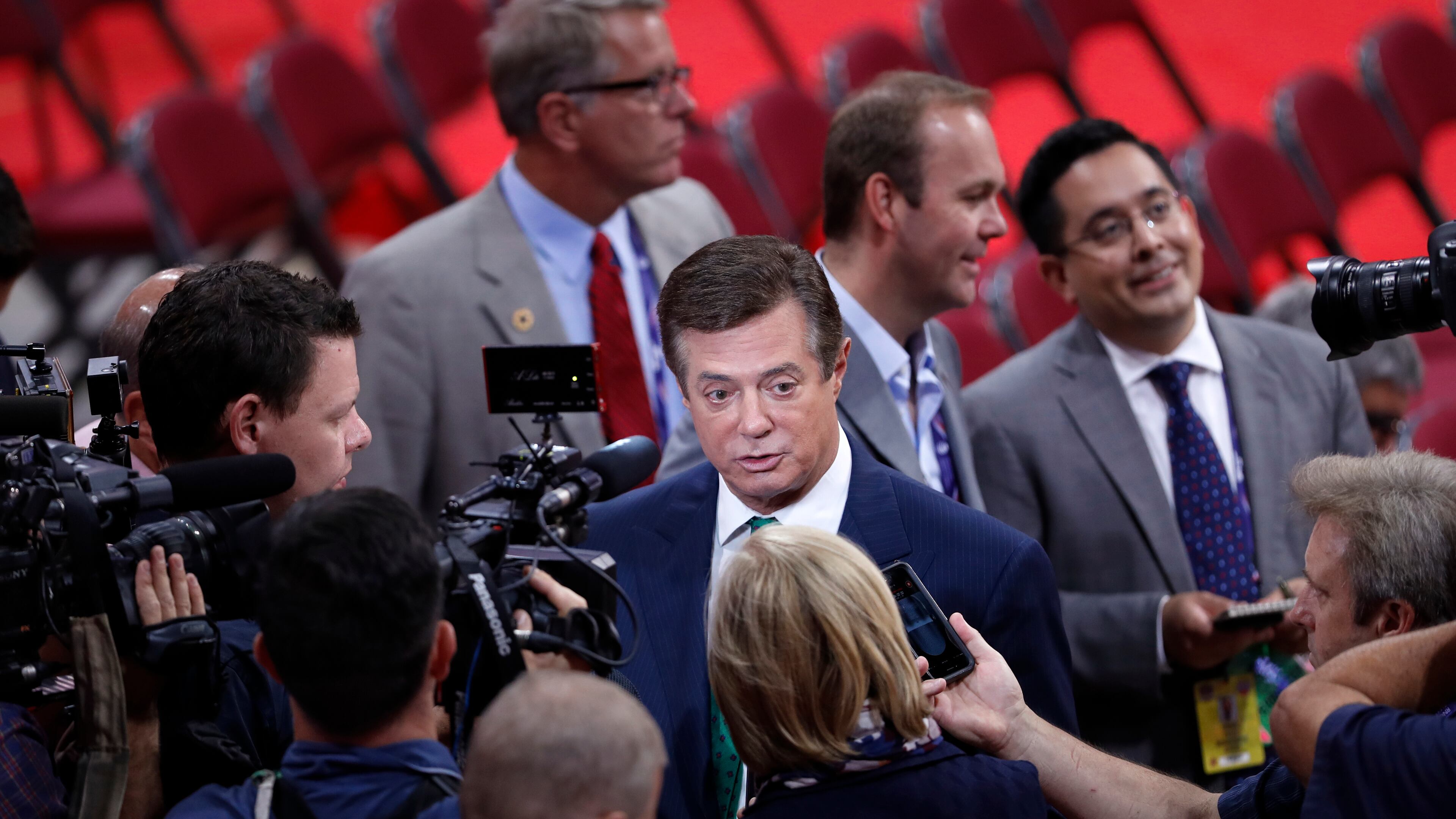 Trump Campaign Chairman Paul Manafort is surrounded by reporters on the floor of the Republican National Convention in Cleveland, Sunday, July 17, 2016. Donald Trump's presidential campaign has hired new staffers to manage the efforts of newly named vice presidential candidate Gov. Mike Pence of Indiana. (AP Photo/J. Scott Applewhite)