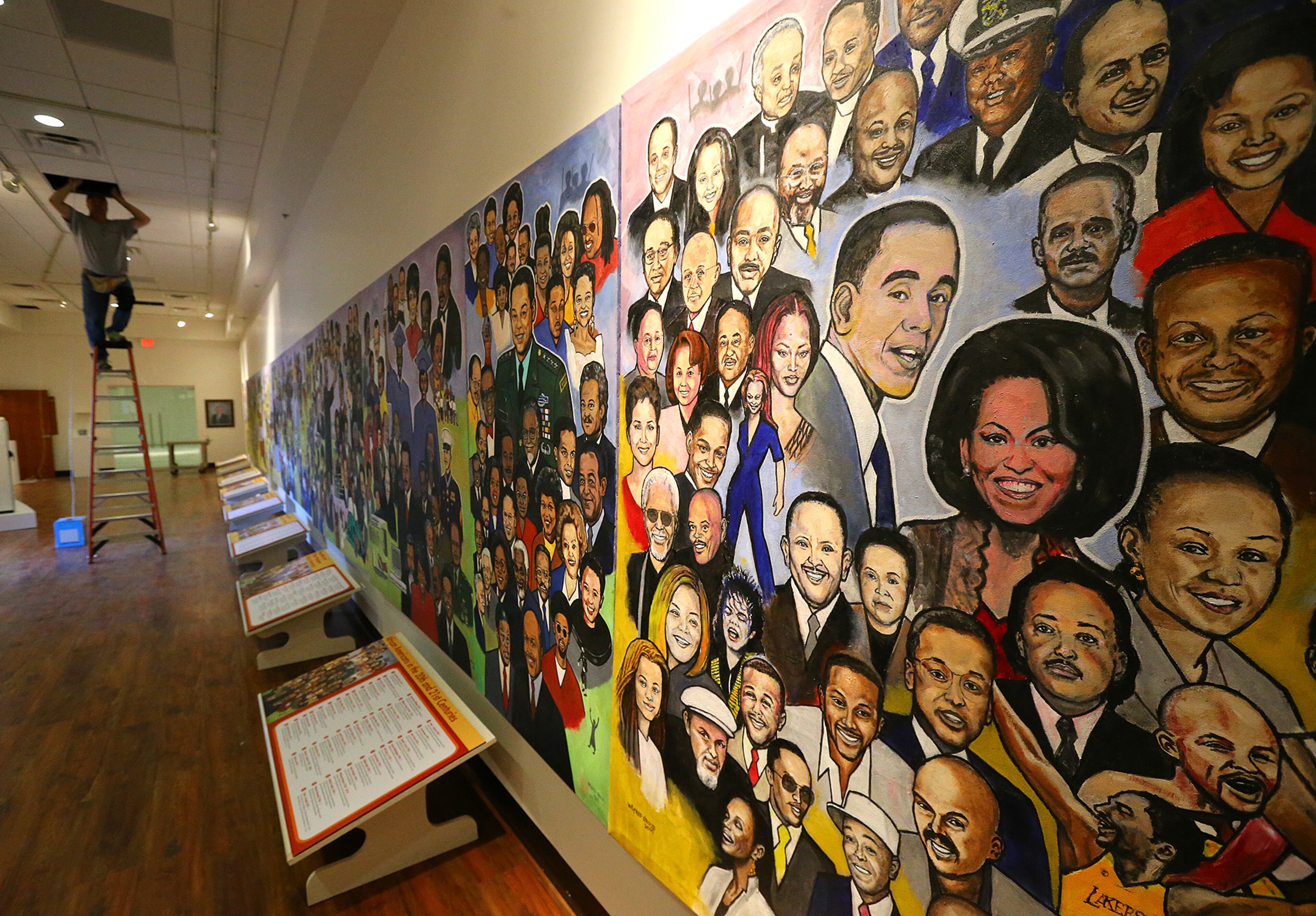 A worker puts final touches on a room that includes a nine-panel mural by Wilfred Stroud at the Tubman Museum of African American Art, History and Culture on Wednesday, May 6, 2015, in Macon. Curtis Compton / ccompton@ajc.com