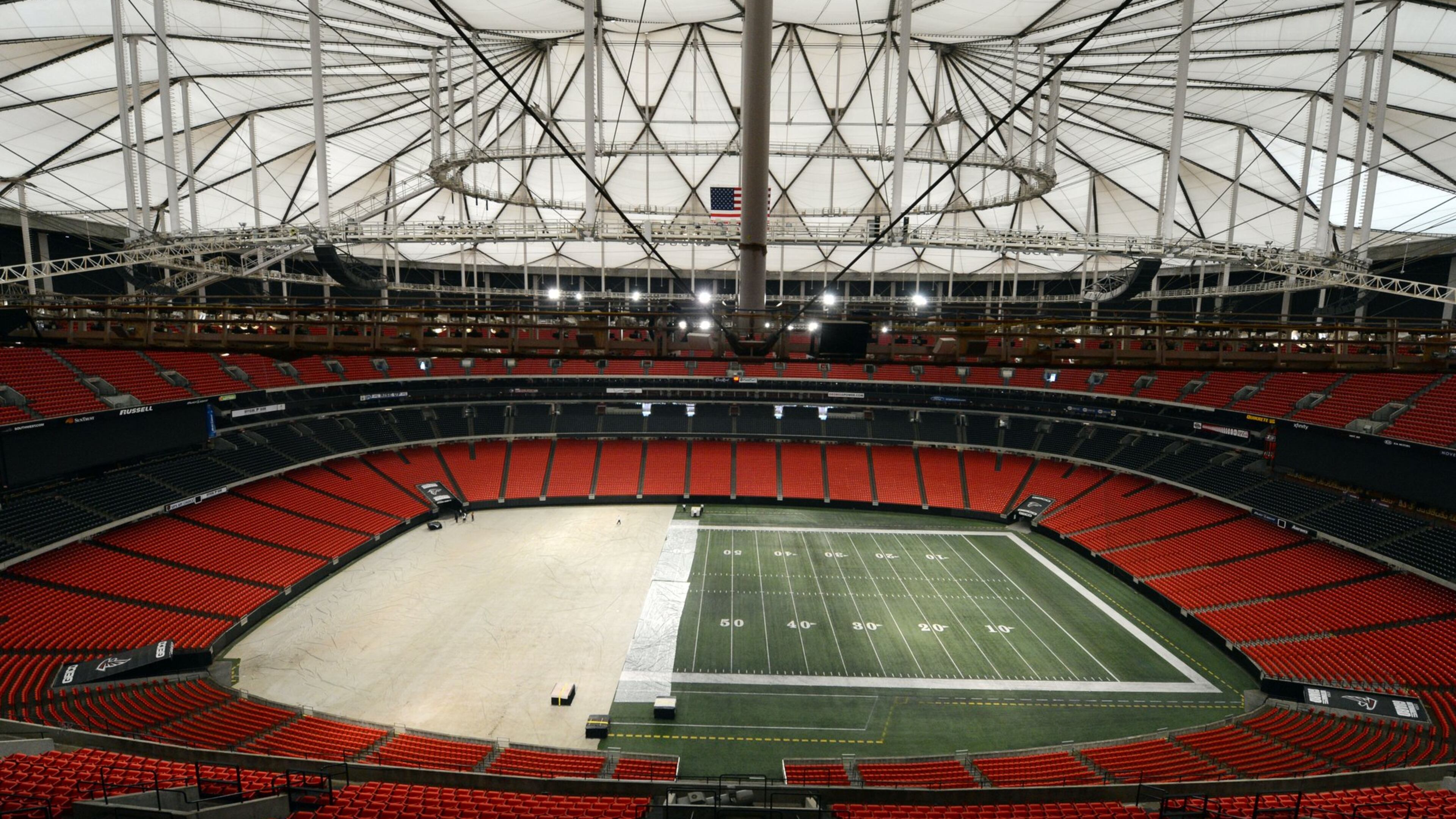 Work crews cover the playing field at the Georgia Dome with a tarp in preparation for the upcoming Monster Truck event. Mayor Kasim Reed’s argument that Atlanta needs a new stadium is being augmented by a new charge: the Georgia Dome is in need of hundreds of millions in renovations, including a new roof.