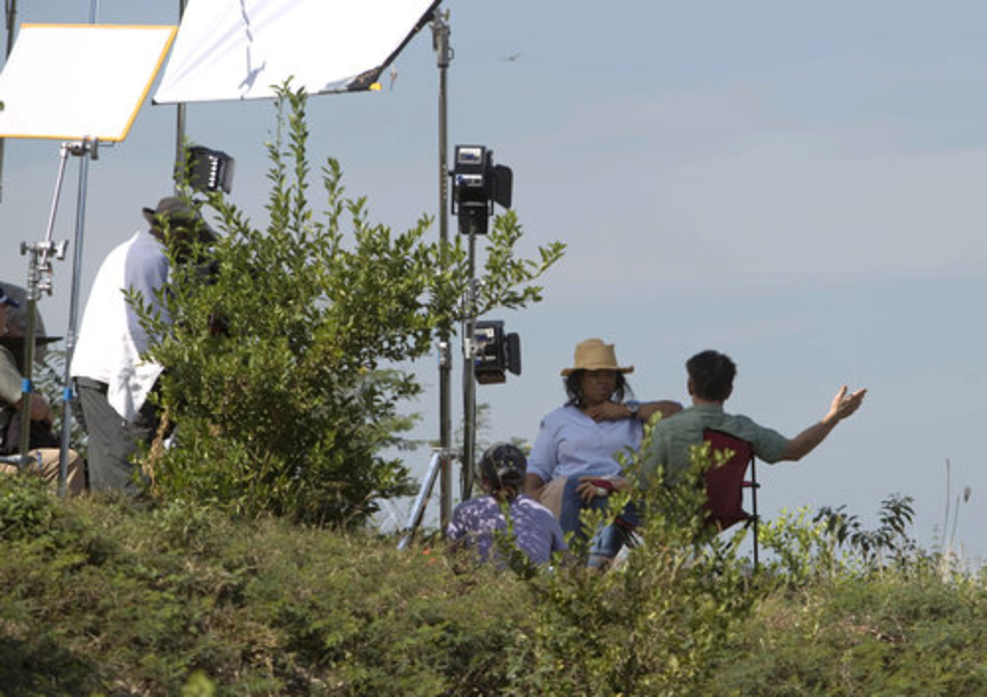 Oprah Winfrey, facing camera, sits with actor Sean Penn. Winfrey says her visit will be shown in upcoming programming on her cable network OWN.
