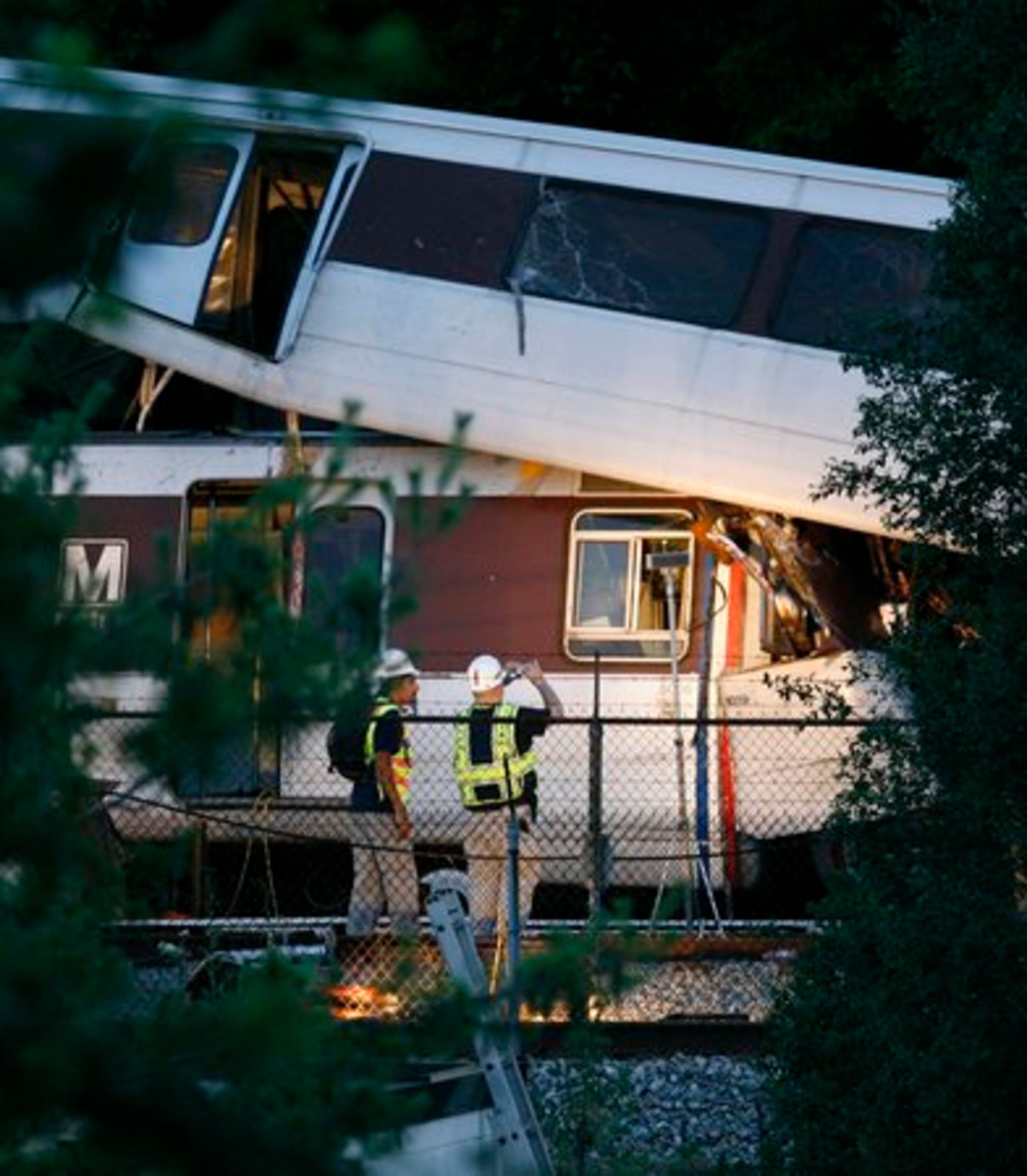 National Transportation Safety Board investigators takes photographs of the wreckage. One subway car sat fully on top of a car from the other train. One of the trains had part of its roof sheared off, but the wreckage was a jumble of twisted metal. Seats from the smashed cars had spilled onto the tracks.