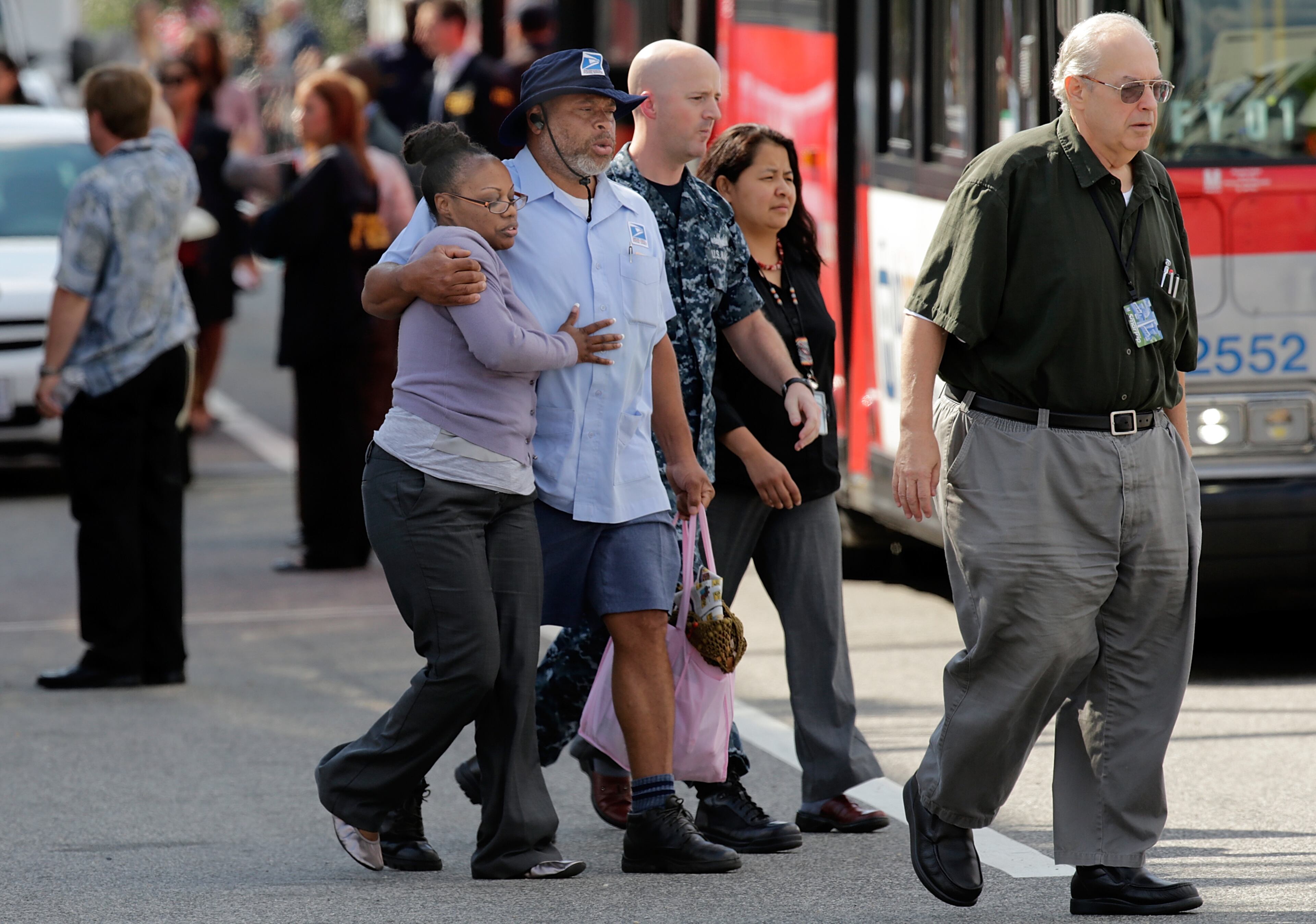 After a bus dropped off employees recently released from the Navy Yard complex, a couple walks away from a gathering point for families that was set up inside Nationals Park in the wake of the Navy Yard shooting Sept. 16, 2013, in Washington, D.C.