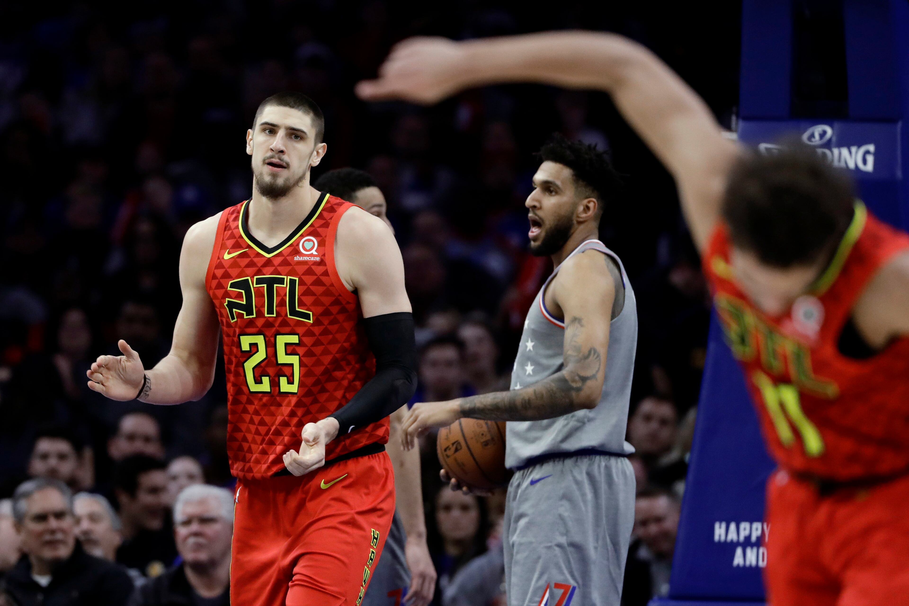 Atlanta Hawks' Alex Len (25) and Trae Young (11) celebrate past after a basket by Len during the second half of an NBA basketball game, Friday, Jan. 11, 2019, in Philadelphia. Philadelphia 76ers' Jonah Bolden is at center. Atlanta won 123-121. (AP Photo/Matt Slocum)