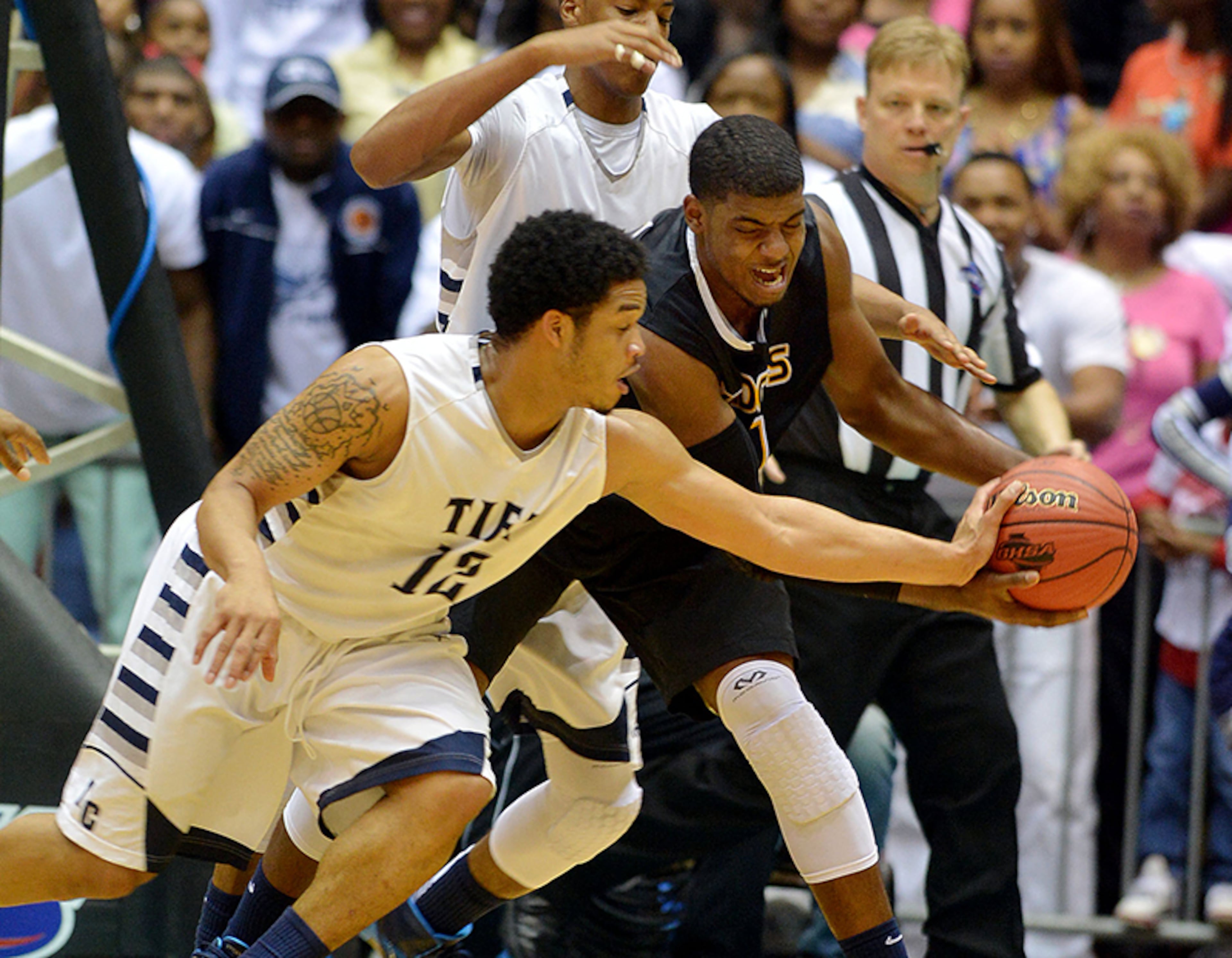 Tift County's Tadric Jackson (12) defends Wheeler's Elijah Staley. The Blue Devils won the Class AAAAAA over the Wildcats, 63-49, Saturday, March 8, 2014, in Macon.