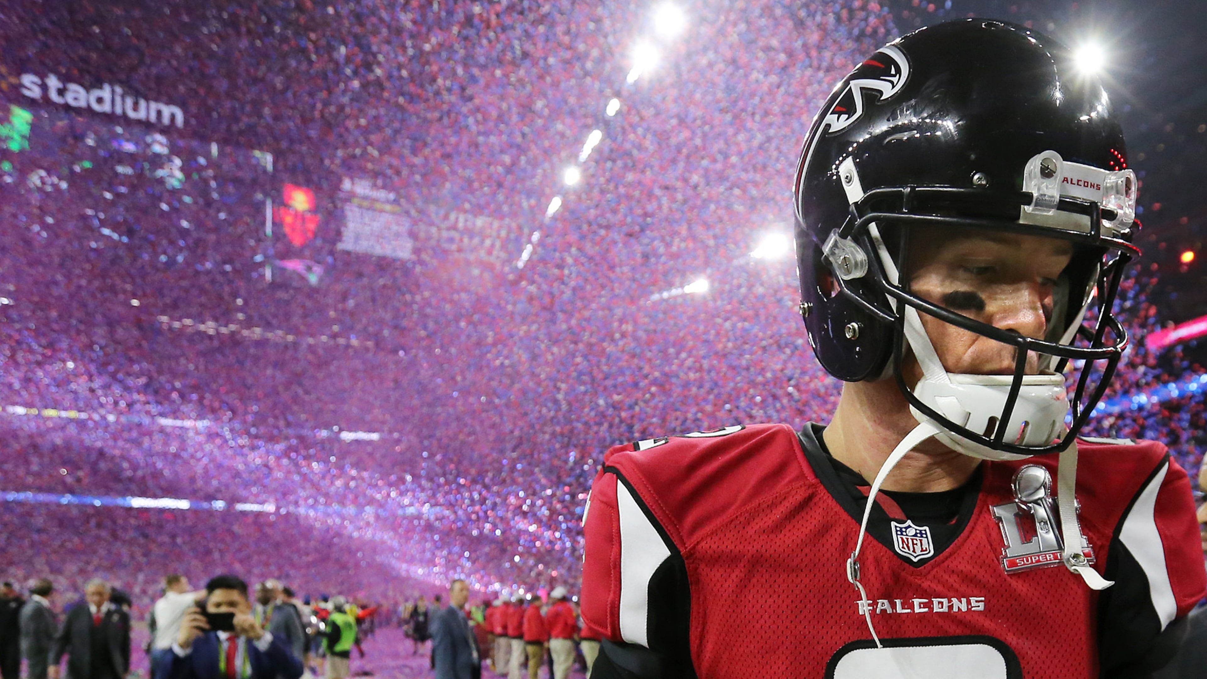 A dejected Matt Ryan walks off the field as the confetti falls to celebrate the Patriots' 34-28 in the 2017 Super Bowl.