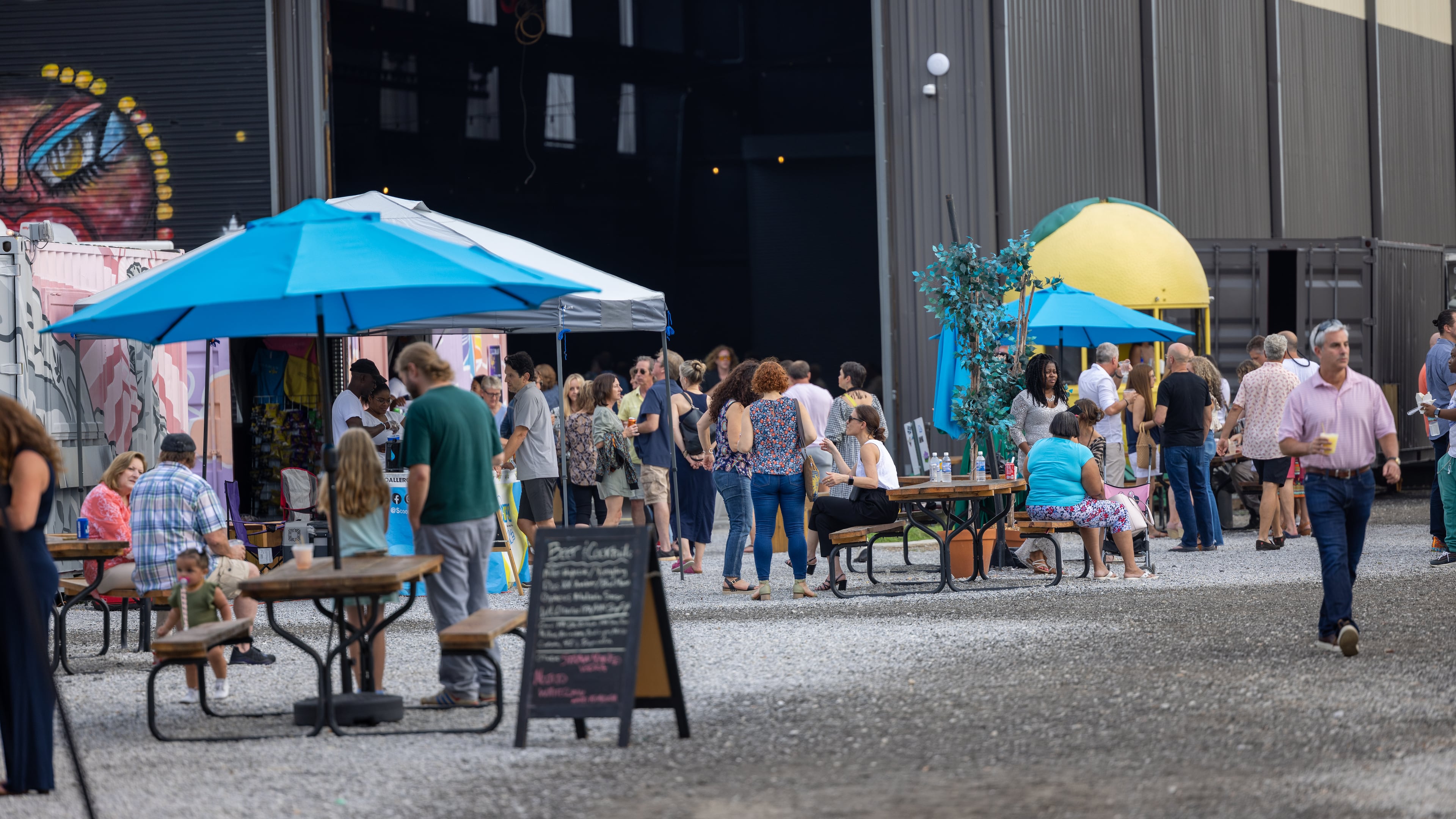 People walking around and buying from food trucks at Pratt Pullman Yard on August 20, 2022