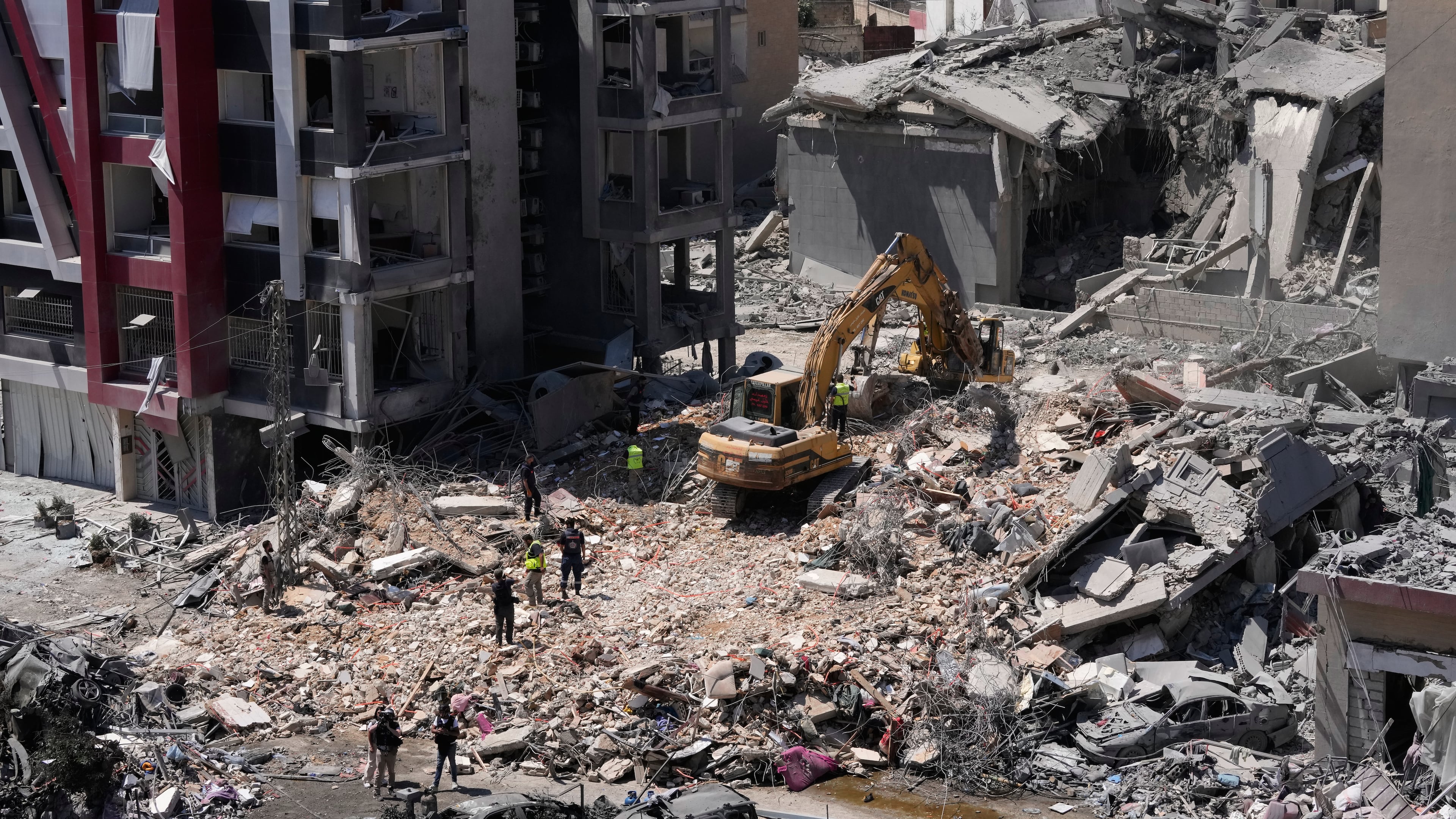 Rescue workers use an excavator, as they search for victims under the rubble of a building that was hit Monday in an Israeli airstrike in the southern port city of Tyre, Lebanon, Tuesday, June 2, 2026. (AP Photo/Mohammed Zaatari)
