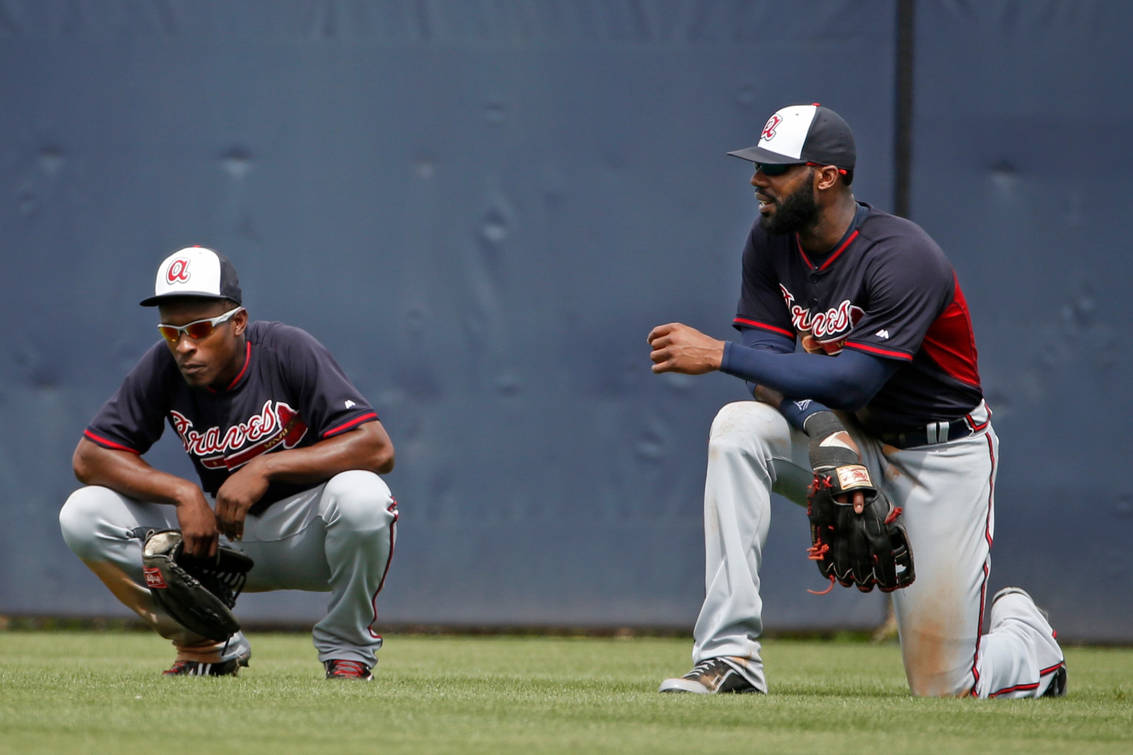 Atlanta Braves center fielder B.J. Upton and right fielder Jason Heyward take a break in the outfield while waiting out a pitching change in the fifth inning of the Braves 7-4 loss to the New York Yankees in a spring exhibition baseball game in Tampa, Fla., Sunday, March 16, 2014. (AP Photo/Kathy Willens)