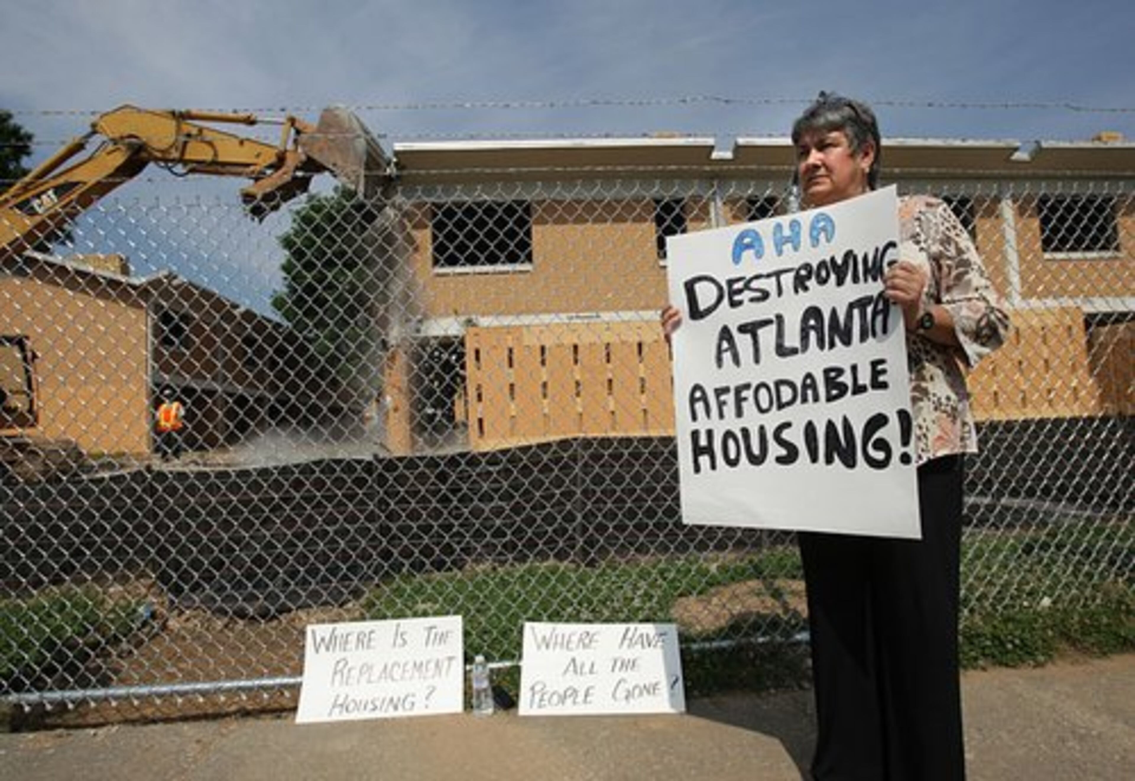 Dianne Mathiowetz stands outside Bowen Homes on Wednesday, protesting the loss of affordable housing in the city of Atlanta.
