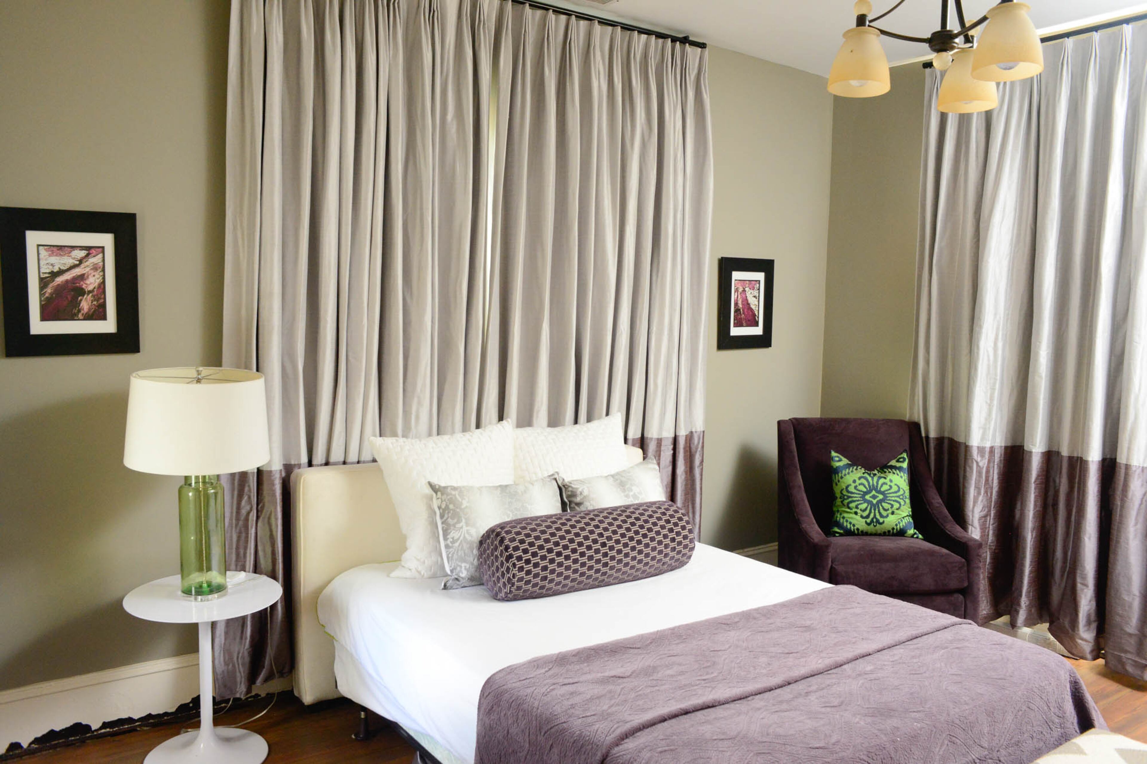 Soothing grays and lavenders add a luxe look to the guest bedroom. Two-toned drapes span from floor to ceiling and draw the eye upward.