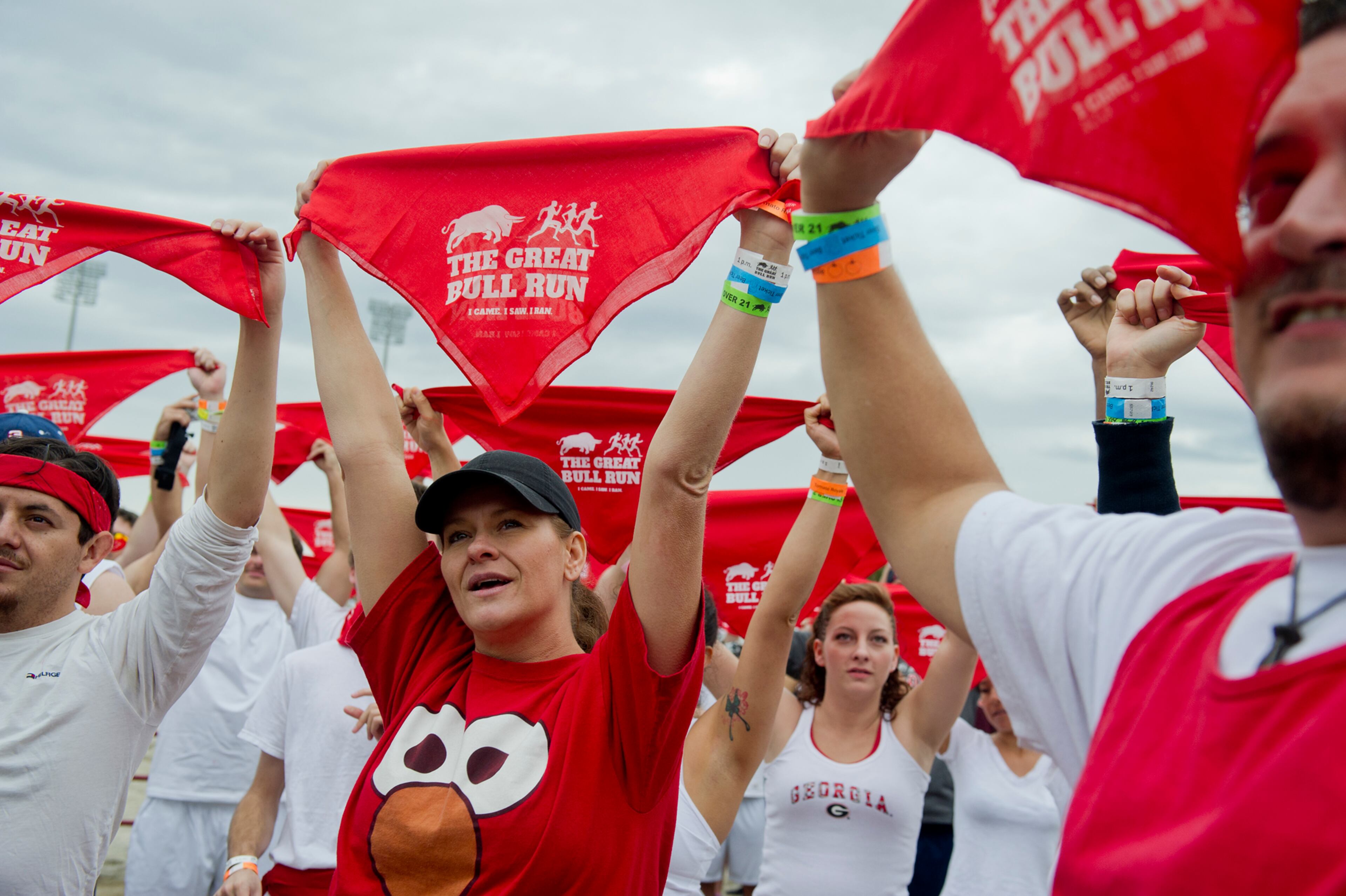 Dawn Poague (center) holds up her bandana with the other participants in her heat before the start of the Great Bull Run at the Georgia International Horse Park in Conyers on Saturday, October 19, 2013.