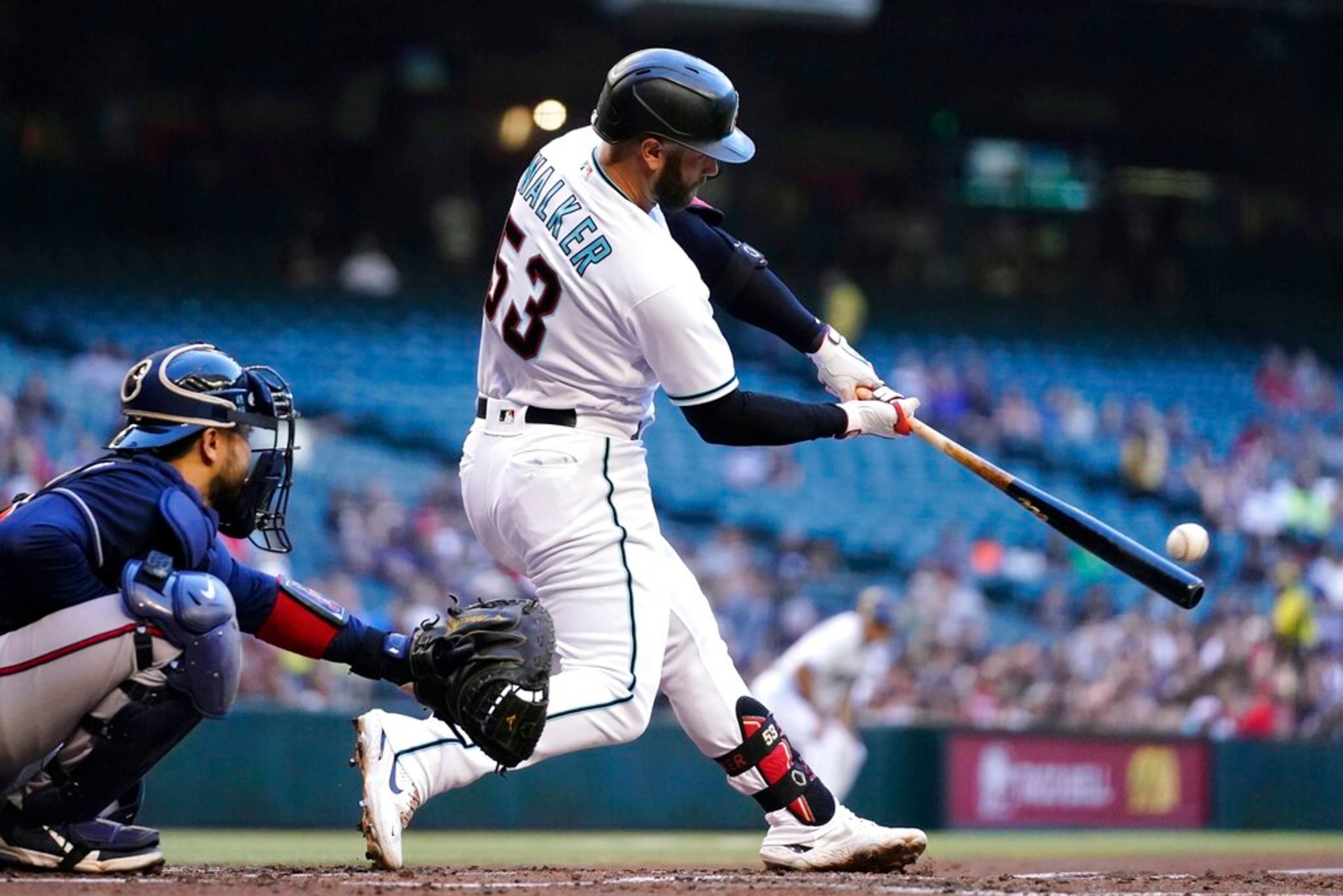 Arizona Diamondbacks' Christian Walker (53) connects for a two-run home run as Atlanta Braves catcher Travis d'Arnaud, left, reaches for the ball during the first inning of a baseball game Tuesday, May 31, 2022, in Phoenix. (AP Photo/Ross D. Franklin)