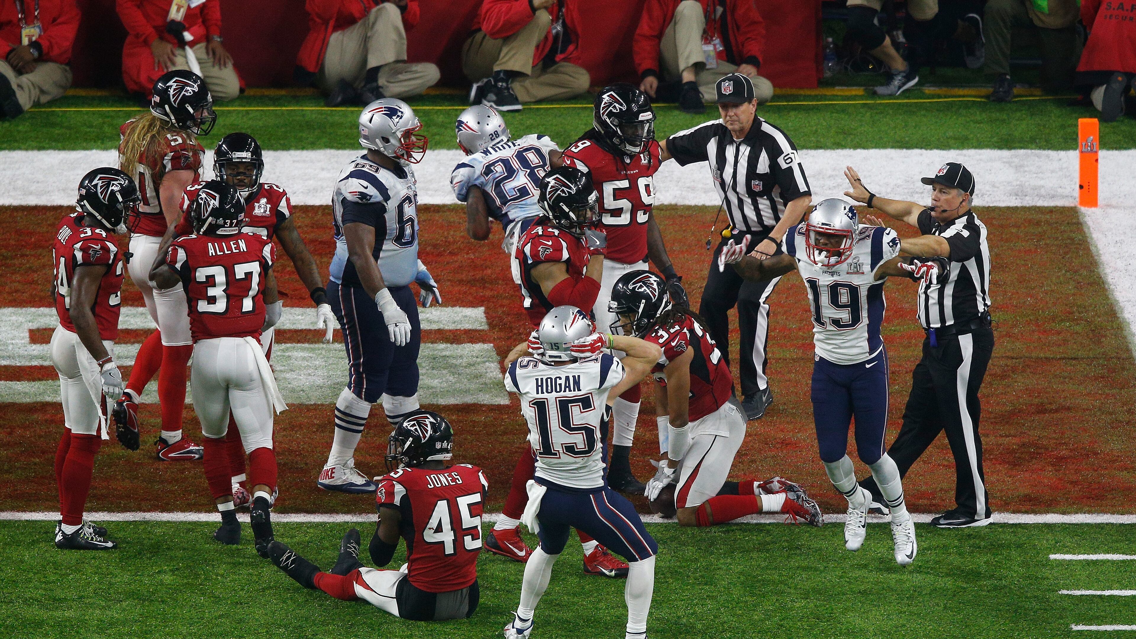 The exact moment Atlanta's heart broke: New England celebrates James White's overtime touchdown while the Falcons contemplate the title that got away. (Bob Levey/Getty Images)