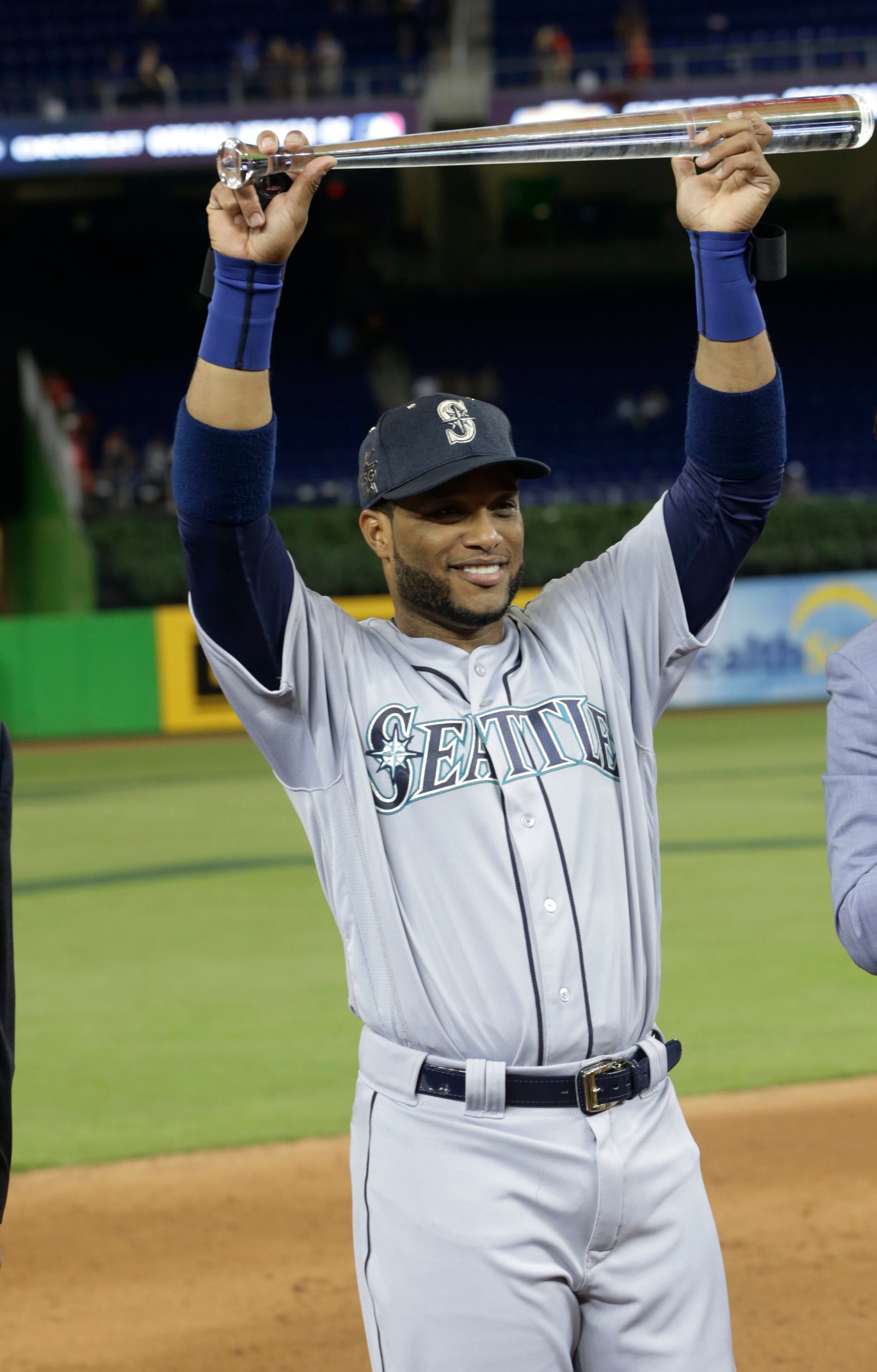 American League's Seattle Mariners Robinson Cano (22), lifts the MLB All-Star MVP trophy, Tuesday, July 11, 2017, in Miami. Robinson hit the game winning home run in the tenth inning. The American League defeated the National League 2-1. (AP Photo/Lynne Sladky)