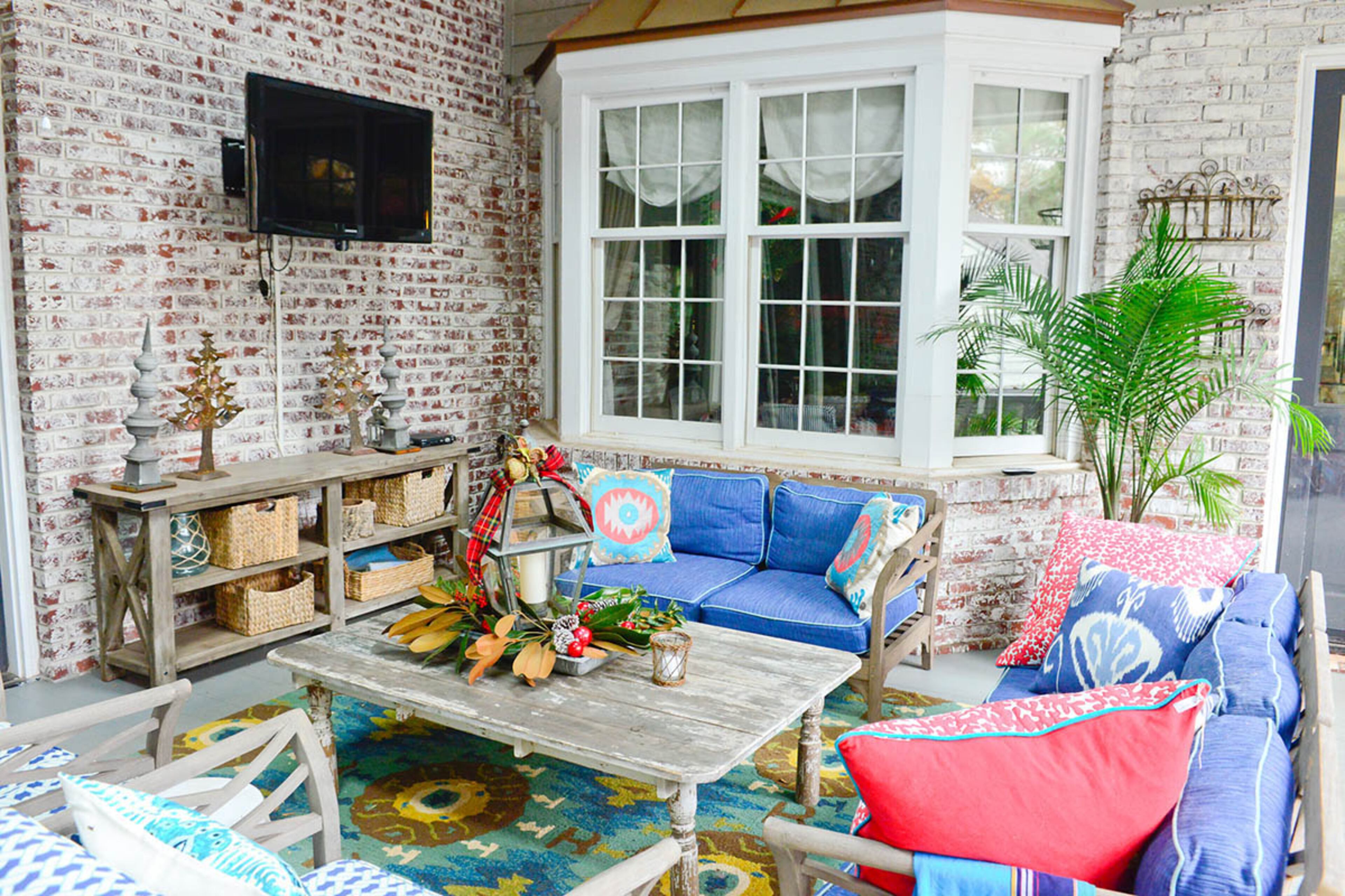 One of the pieces Tom Trocheck made for his Avondale Estates home is a console table on the screened-in porch, which has furniture from RH. Most of the seating is from an estate sale, covered in Sunbrella fabric.