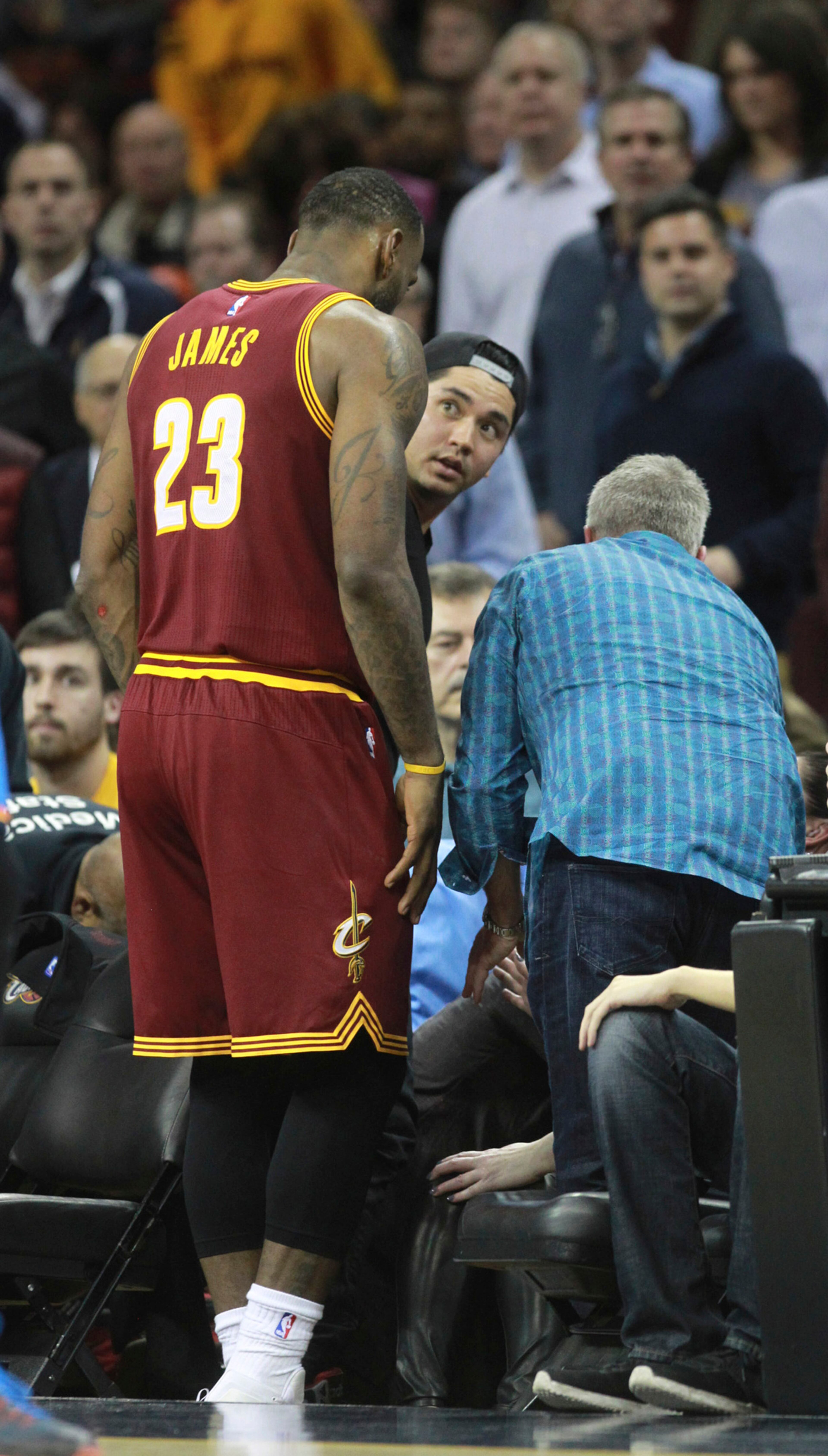 The Cleveland Cavaliers' LeBron James (23) returns to check on Ellie Harvey Day, wife of golfer Jason Day, middle, after chasing a loose ball into the stands against the Oklahoma City Thunder on Thursday, Dec. 17, 2015, at Quicken Loans Arena in Cleveland. Ellie Harvey Day had to be taken from courtside by stretcher. (Phil Masturzo/Akron Beacon Journal/TNS)