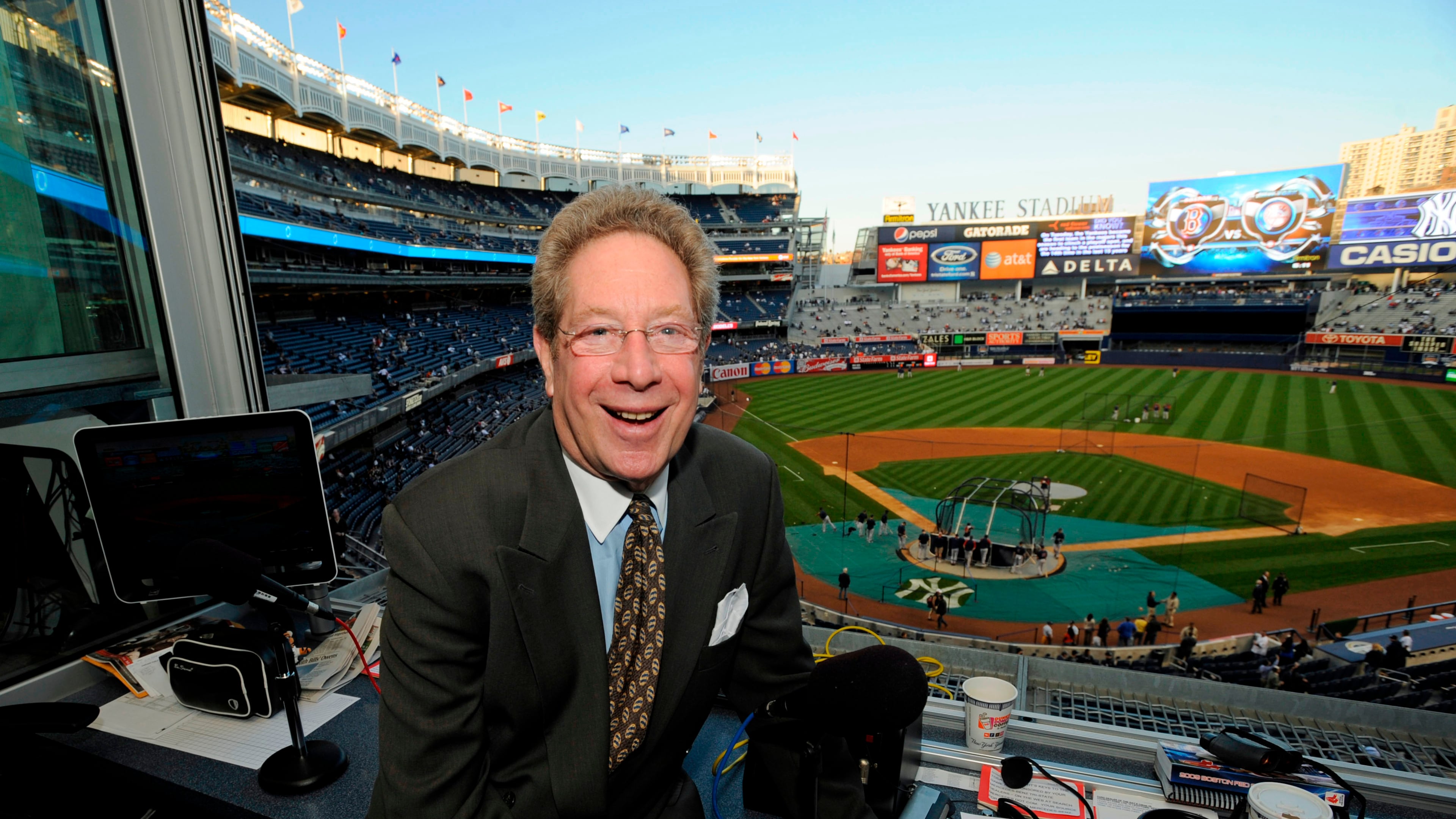 FILE - In this Sept. 25, 2009 file photo shows New York Yankees broadcaster John Sterling sitting in his booth before a baseball game against the Boston Red Sox at Yankee Stadium in New York. (AP Photo/Bill Kostroun, file)