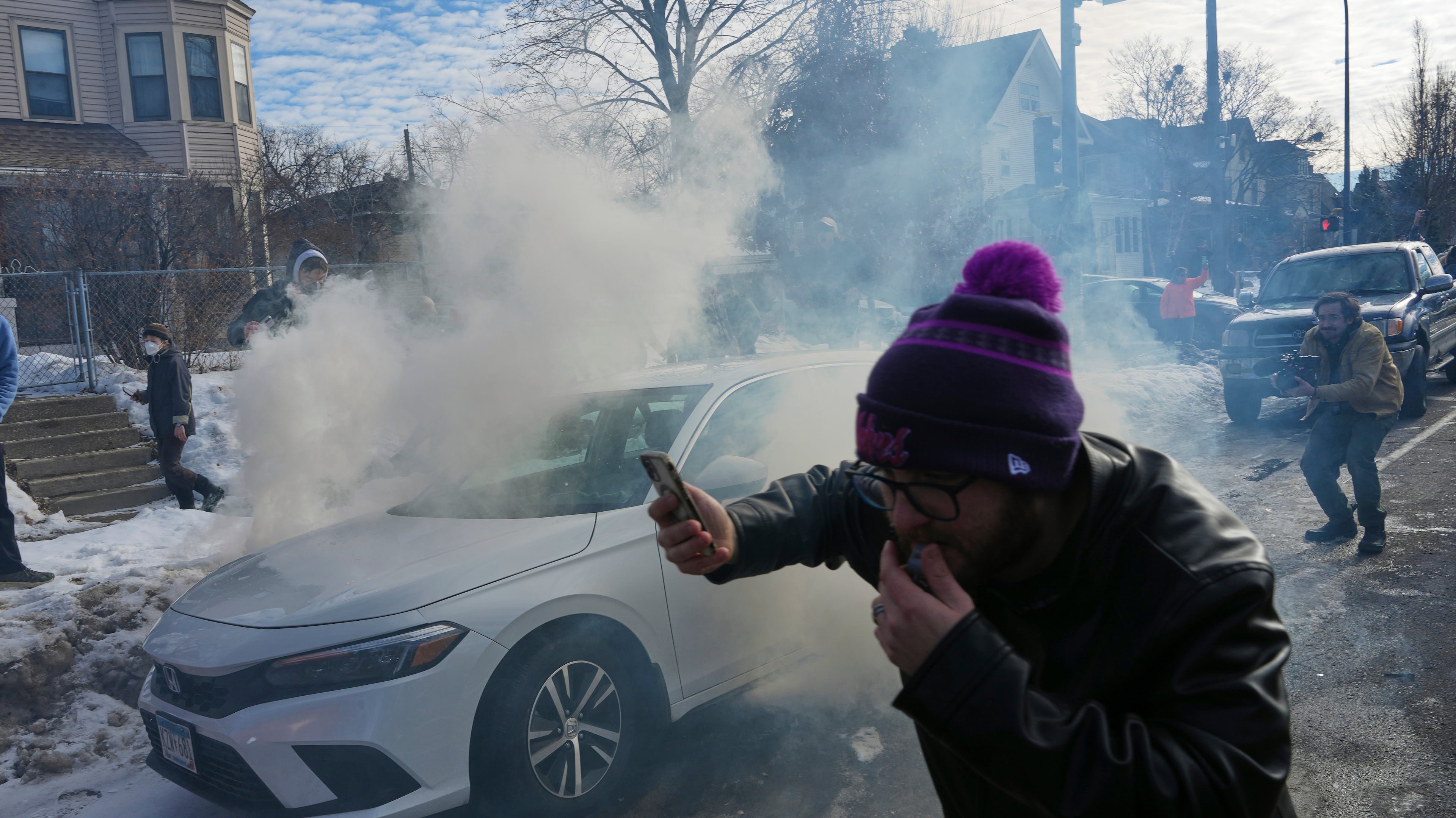 Protesters try to avoid tear gas dispersed by federal agents, Monday, Jan. 12, 2026 in Minneapolis (AP Photo/Adam Gray)