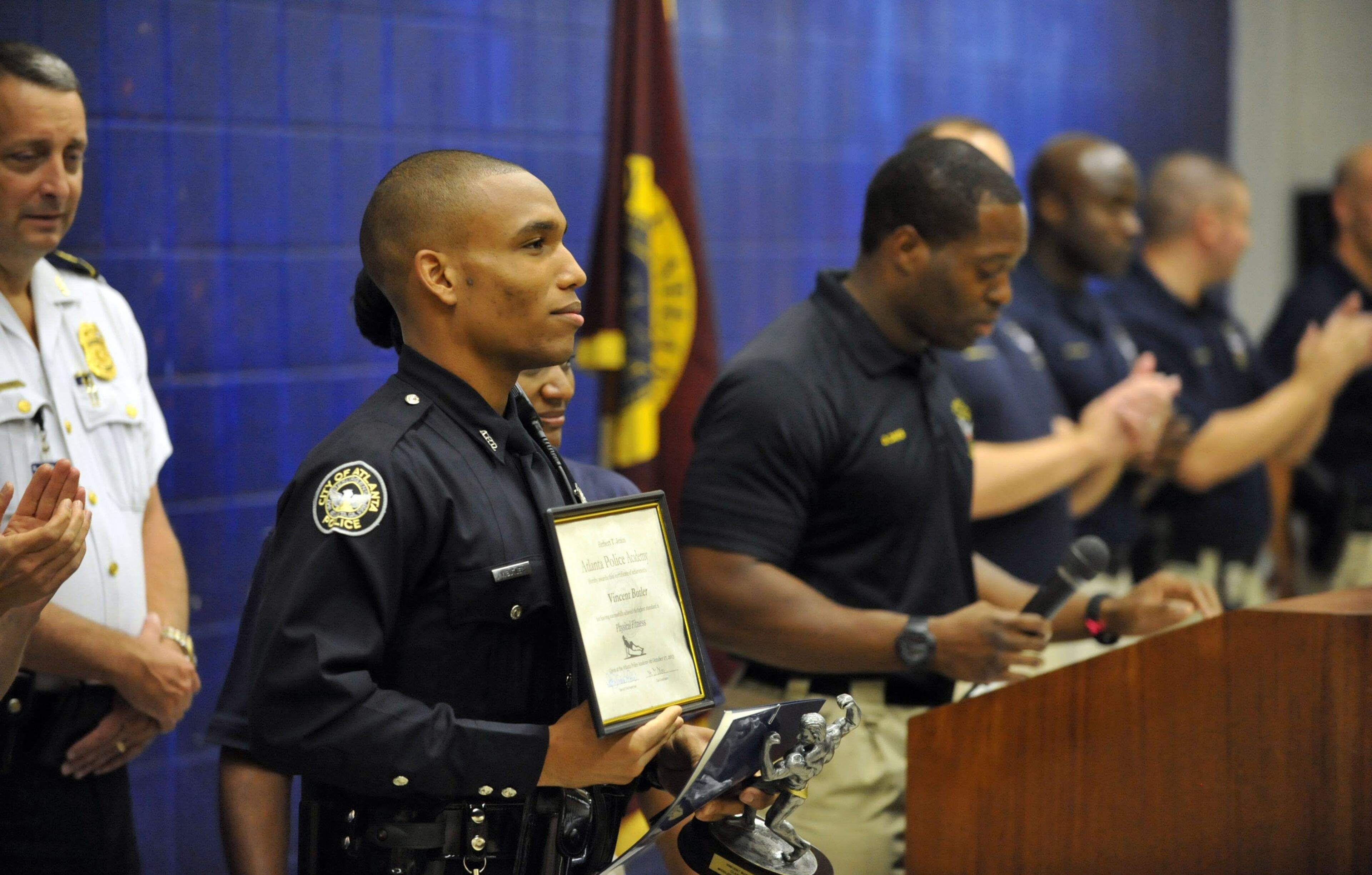 New Officer Vincent Butler stands with his physical fitness award. His mile run time broke an academy record. The Atlanta Police Department swore in officers with Class #232 at the Atlanta Police Training Academy on Thursday, October 17, 2013. Twenty-six officers participated in the ceremony that concludes 22 weeks of rigorous training at the Atlanta Police Academy. Training consisted of classroom courses in constitutional law, local and state laws, Atlanta Police Department policy and procedure, hands-on defensive tactics, arrest techniques and daily physical fitness. Next, these officers will experience 12 weeks of field training with veteran officers. KENT D. JOHNSON / KDJOHNSON@AJC.COM