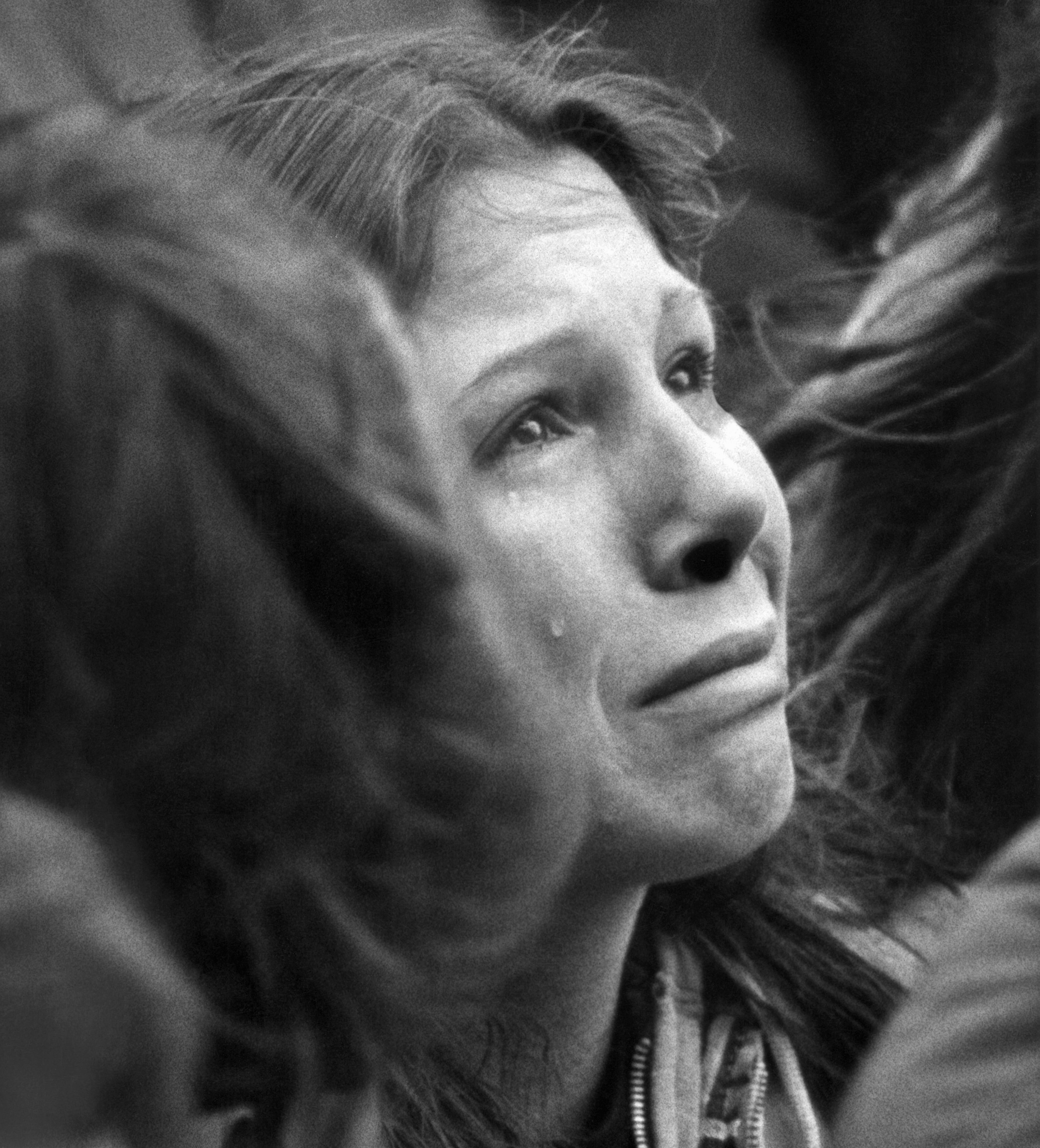 In this Dec. 14, 1980, file photo, a woman weeps during a ten minute silent vigil for John Lennon held in front of Trinity Church in Boston. An estimated crowd of 2,000 people came to honor the former Beatle who was murdered in New York. Thirty-five years ago on Dec. 8, Mark David Chapman shot and killed Lennon, a former Beatles member. (AP Photo/John Martell, File)