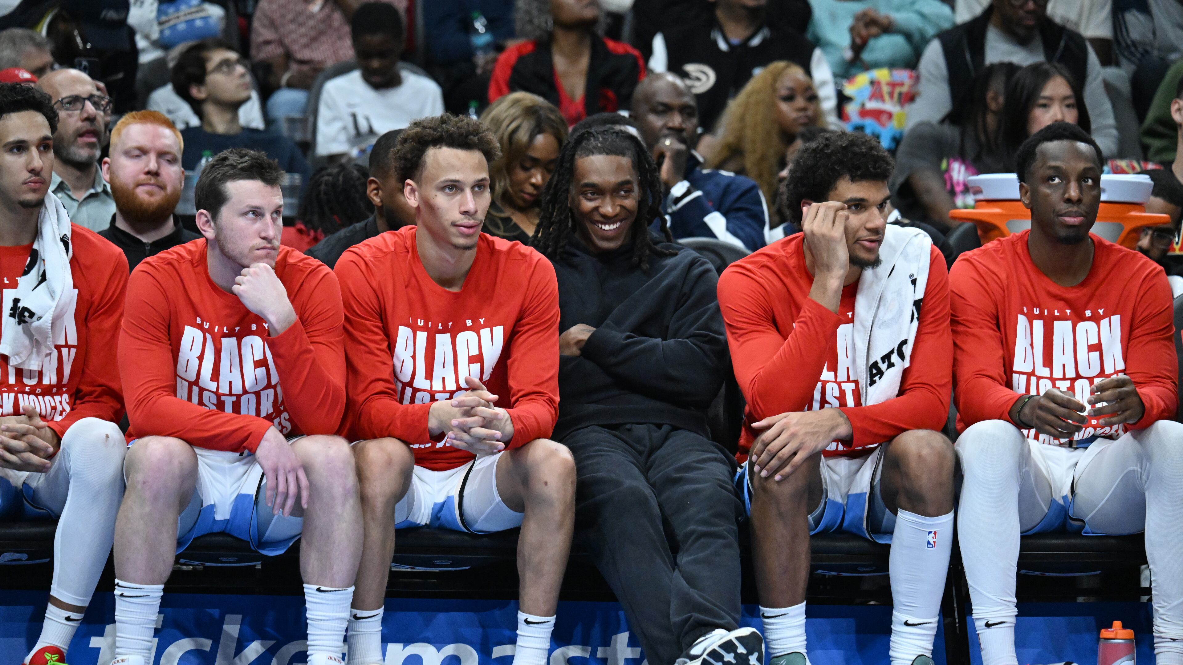 Atlanta Hawks new guard Terance Mann (center) smiles as he sits with teammates during the second half in an NBA basketball game at State Farm Arena, Friday, February 7, 2025, in Atlanta. Atlanta Hawks won 115-110 over Milwaukee Bucks. (Hyosub Shin / AJC)