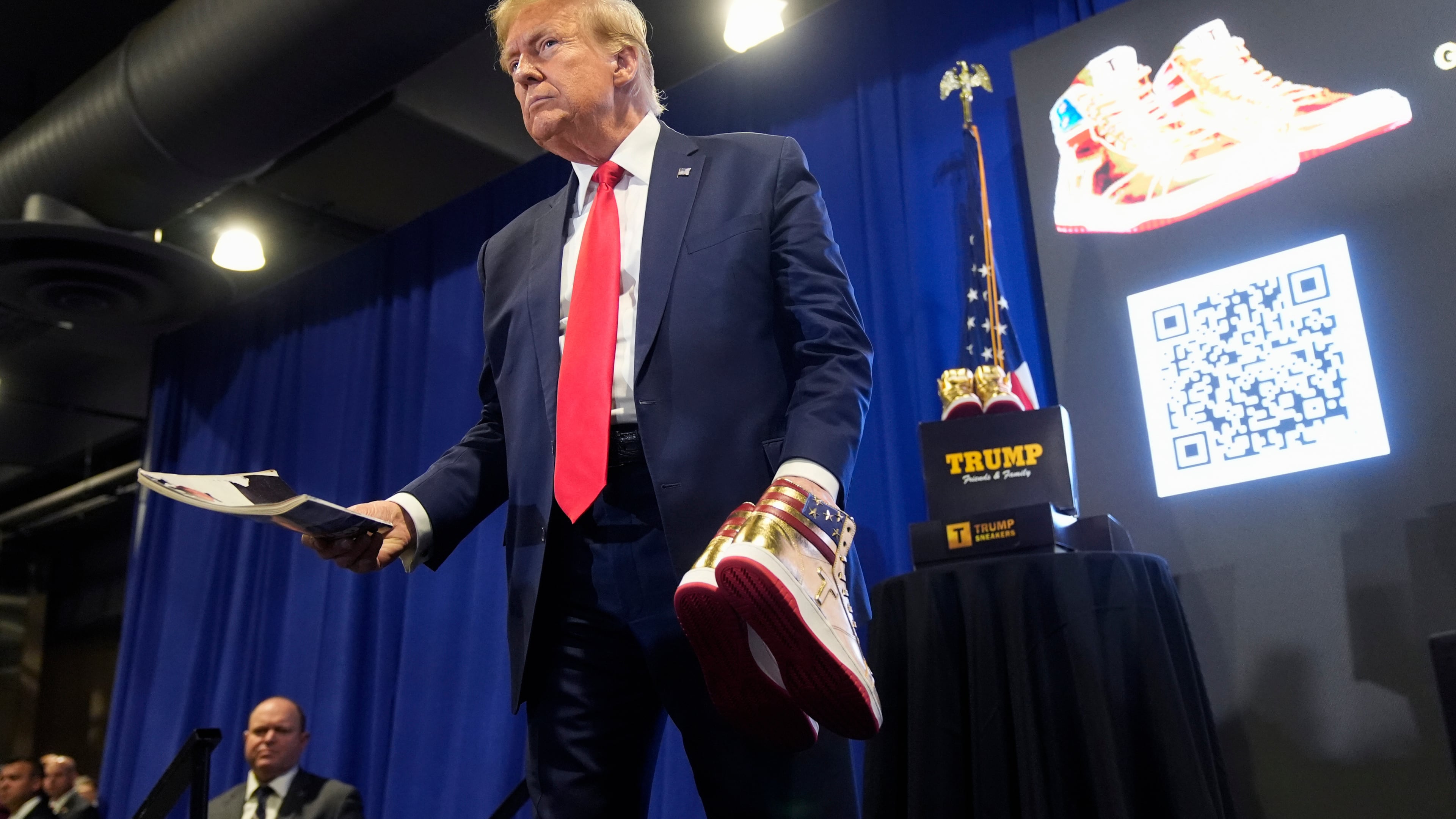 FILE - Donald Trump holds a Playboy magazine and gold Trump sneakers at Sneaker Con Philadelphia, an event popular among sneaker collectors, in Philadelphia, Feb. 17, 2024. (AP Photo/Manuel Balce Ceneta, File)