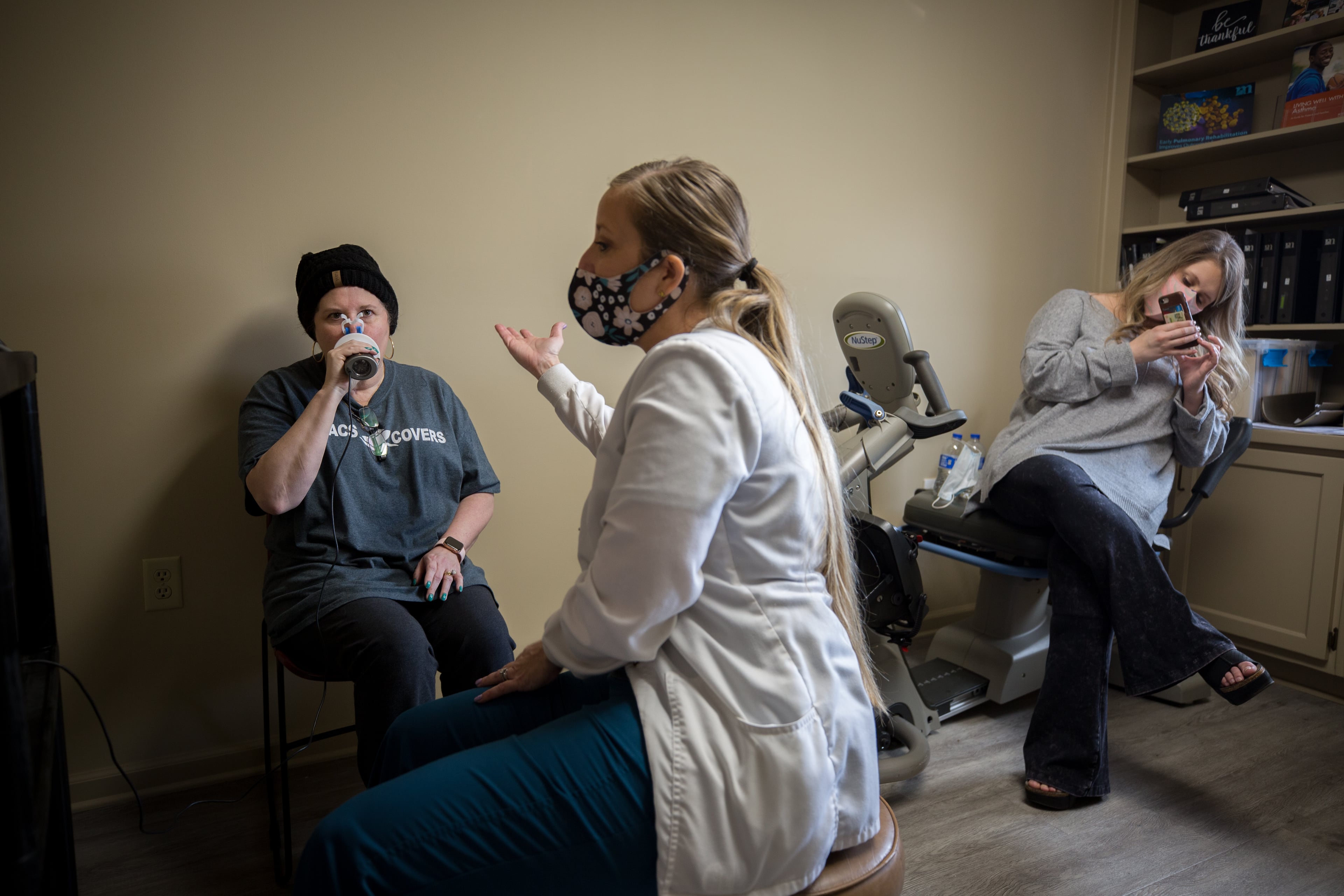 Lisa Martin takes part in a pulmonary function test as Martin’s daughter, Harper Lee, records the treatment on her cell phone. (AJC Photo/Stephen B. Morton)